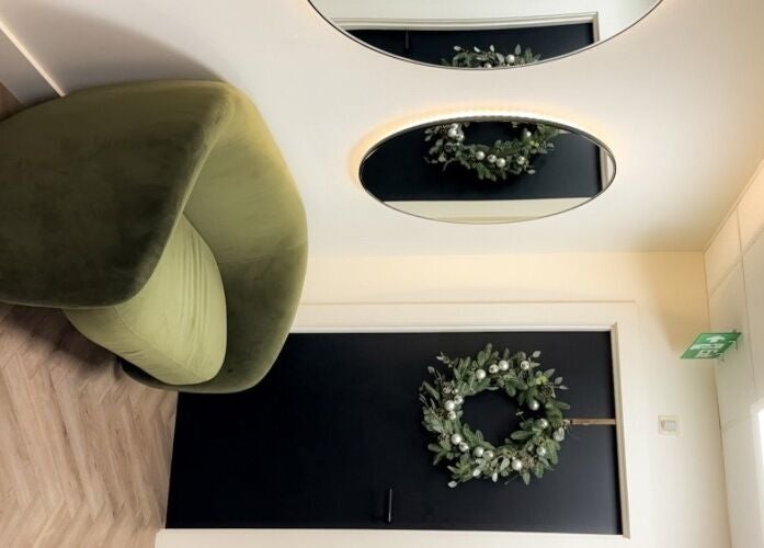 Modern green chair beside a decorated door at Elya Aesthetic in London, England, GB.