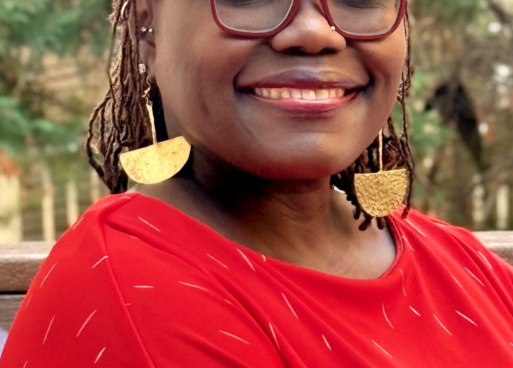 Smiling person in vibrant attire at Tresor Hair Elegance, Dumfries, Virginia, US.
