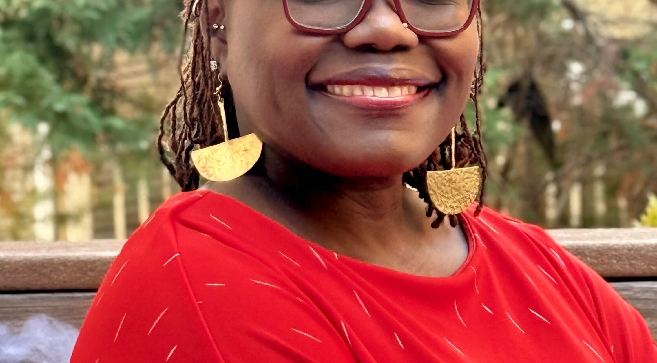 Smiling person in vibrant attire at Tresor Hair Elegance, Dumfries, Virginia, US.