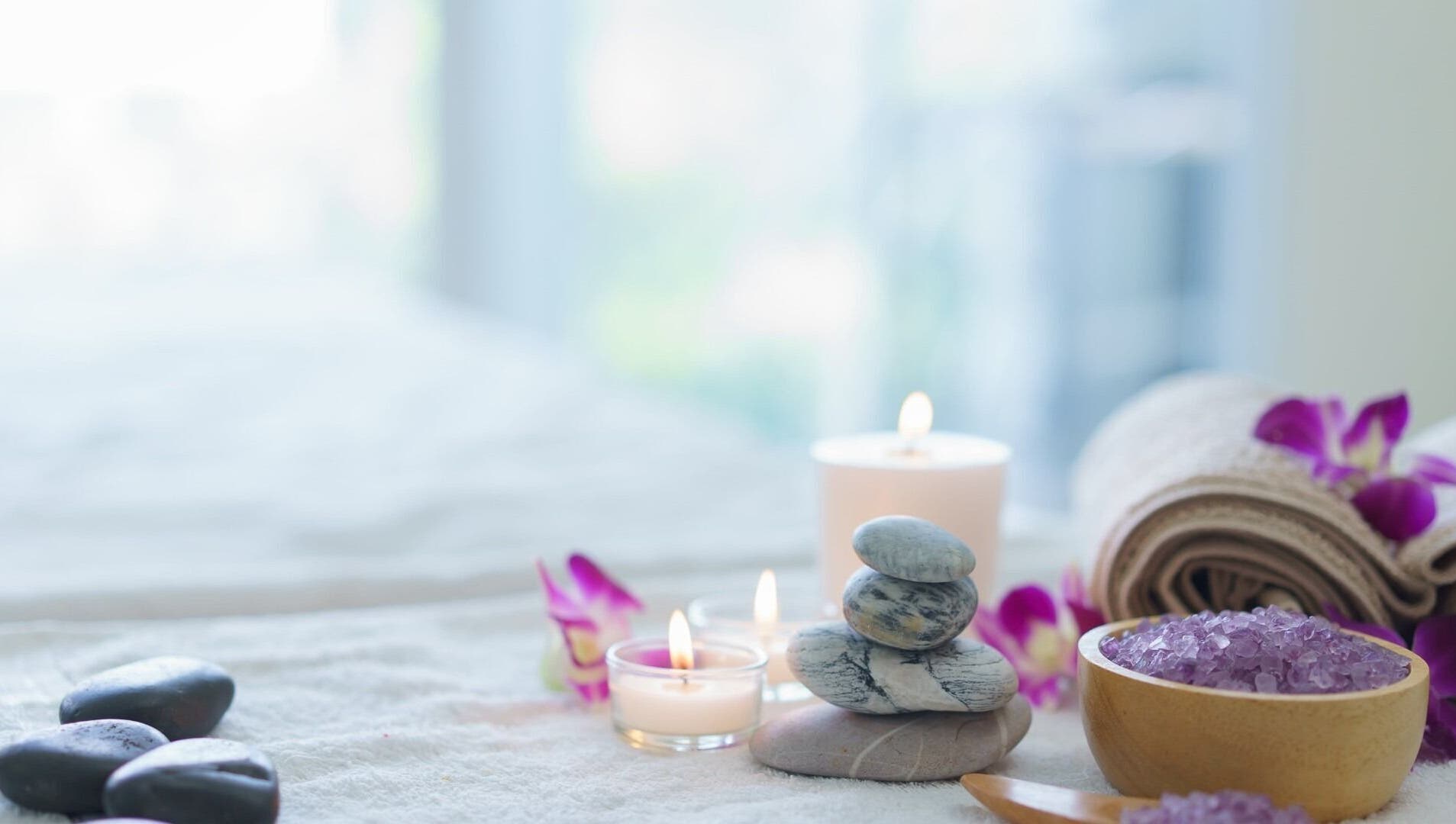 位于马萨诸塞州罗克兰的Harmony Health Spa，展示了一张安静的按摩床，上面放有蜡烛和花瓣。