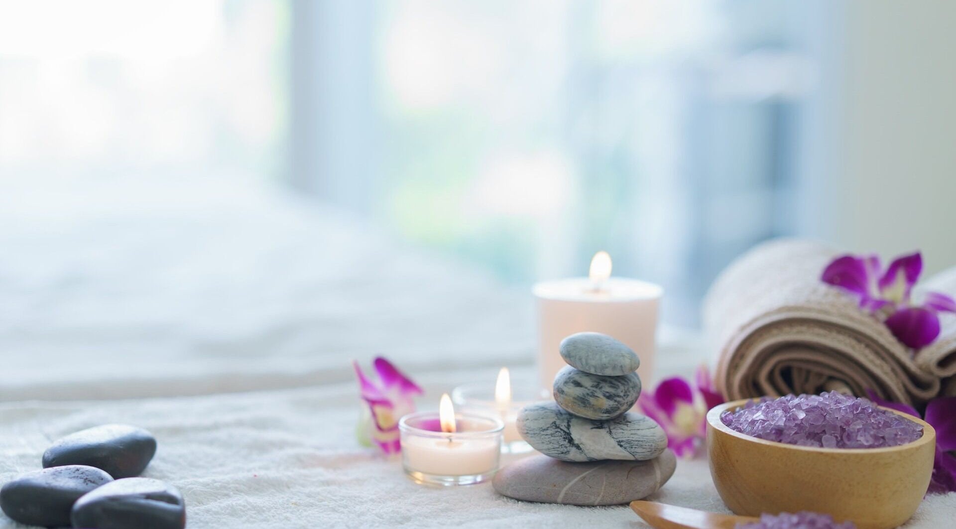 位于马萨诸塞州罗克兰的Harmony Health Spa，展示了一张安静的按摩床，上面放有蜡烛和花瓣。