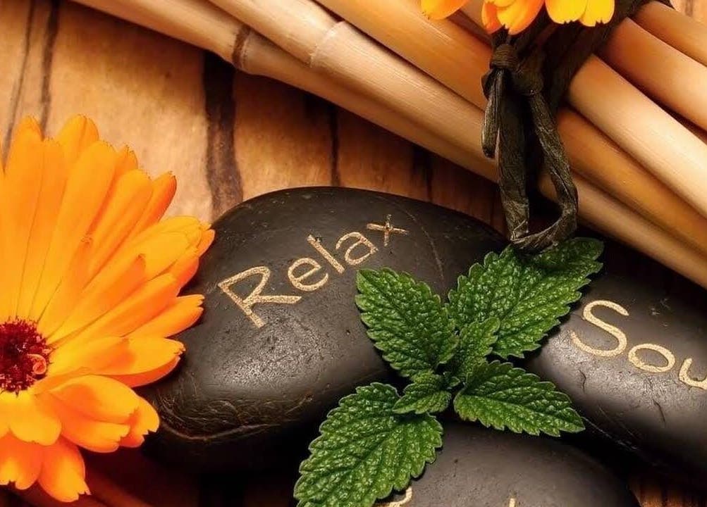 Harmony Health Spa的石头上写着'Relax'与'Soul'，旁边有一朵鲜艳的花，位于美国马萨诸塞州罗克兰。