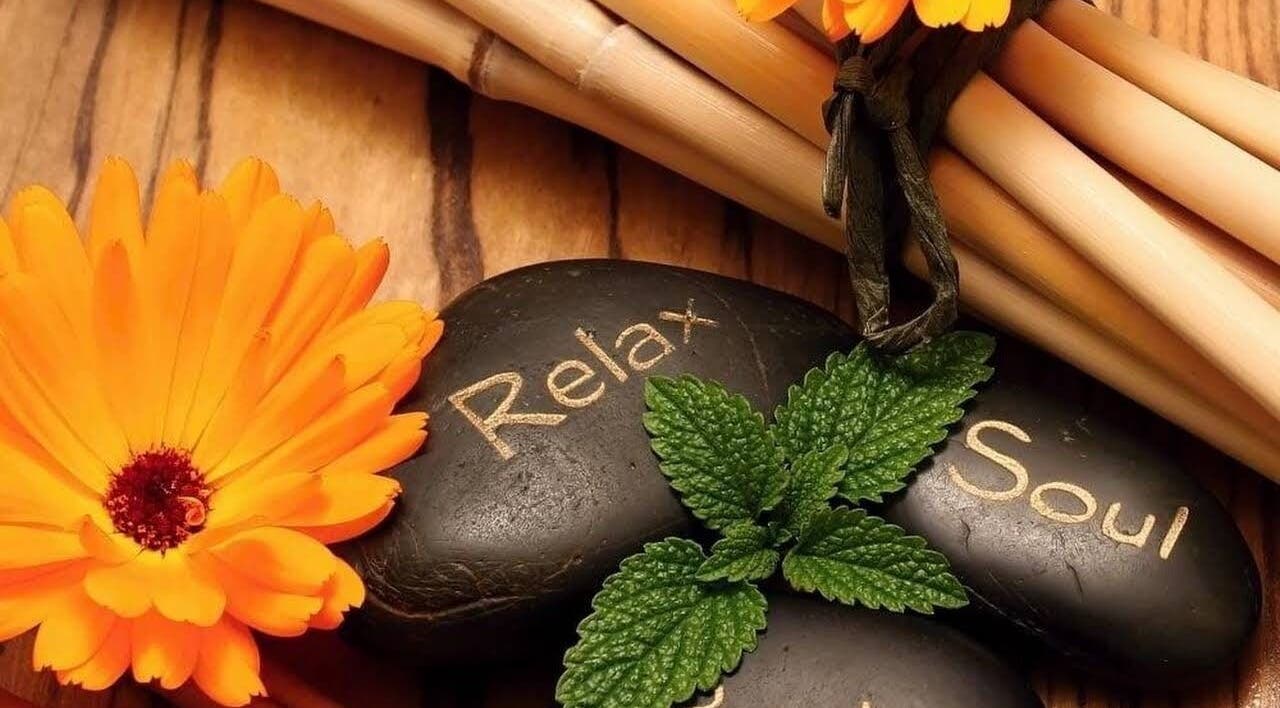 Harmony Health Spa的石头上写着'Relax'与'Soul'，旁边有一朵鲜艳的花，位于美国马萨诸塞州罗克兰。