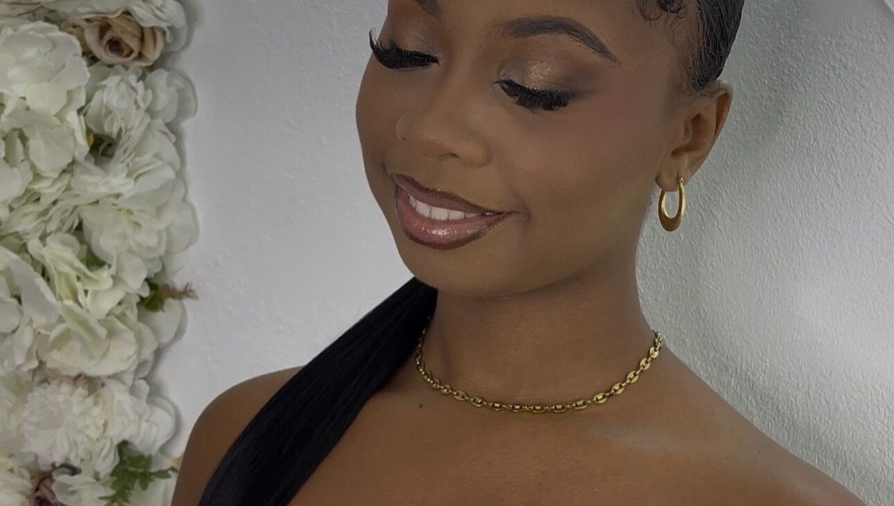 Smiling woman with elegant makeup at Pretty Reflections, Gros Islet, Gros Islet, LC, beside a floral backdrop.