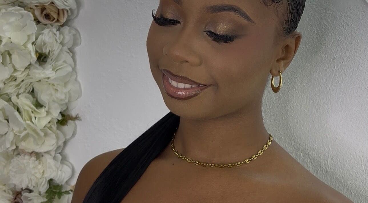 Smiling woman with elegant makeup at Pretty Reflections, Gros Islet, Gros Islet, LC, beside a floral backdrop.