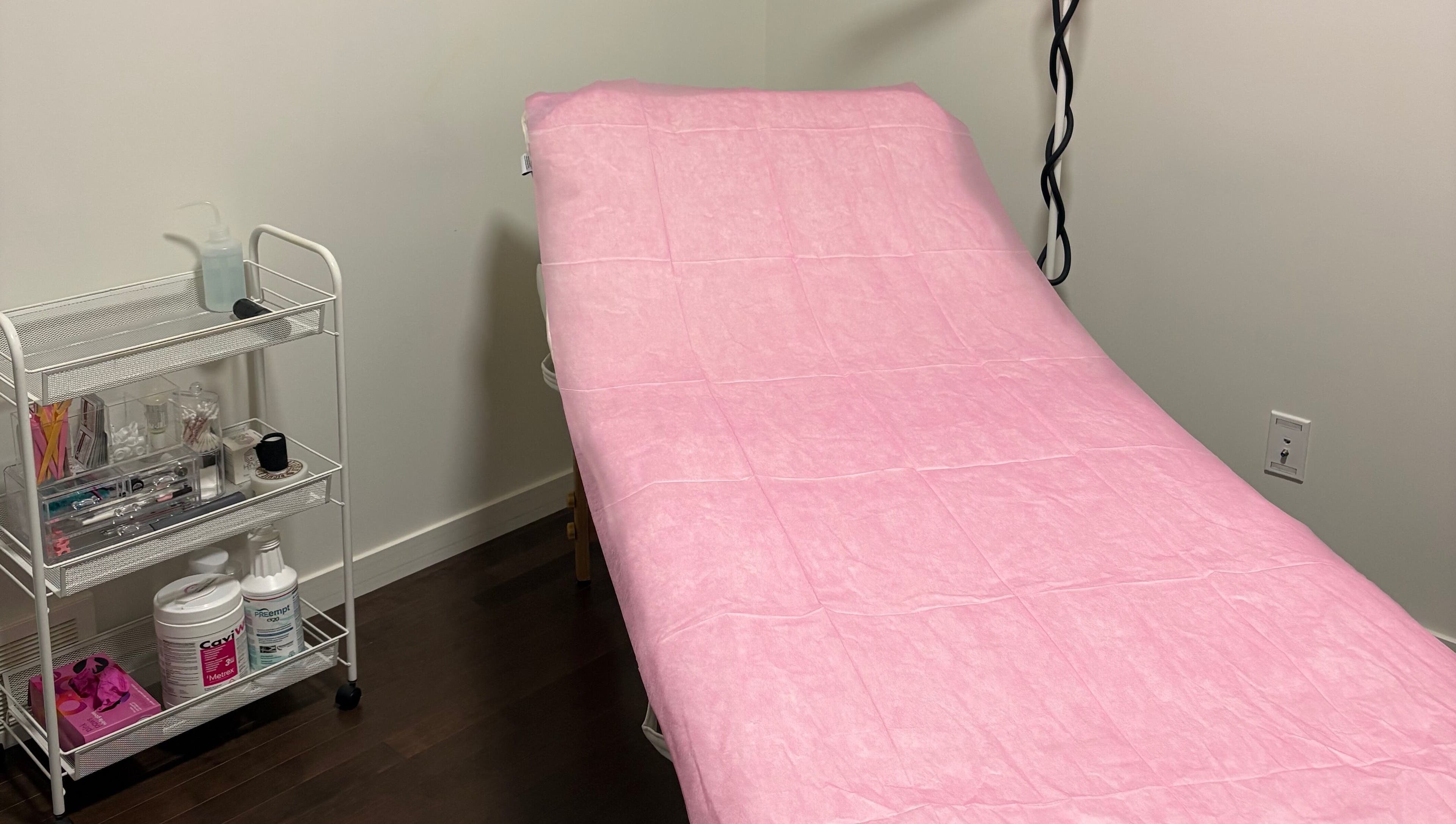 Treatment room with pink-covered bed at Chi Beauty by Aimee in Calgary, Alberta, CA.