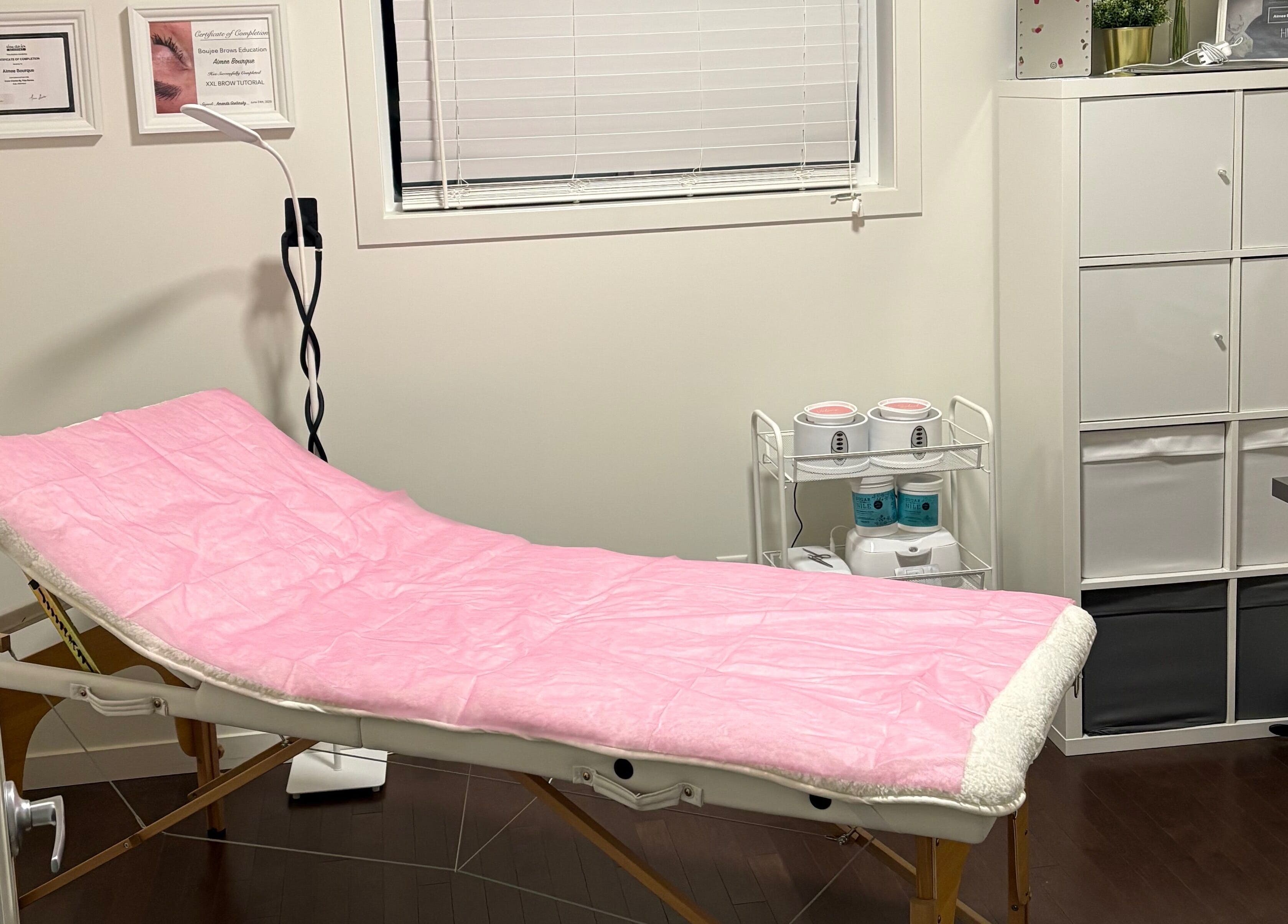 Relaxing treatment room at Chi Beauty by Aimee in Calgary, Alberta, CA, featuring a pink-covered spa bed.