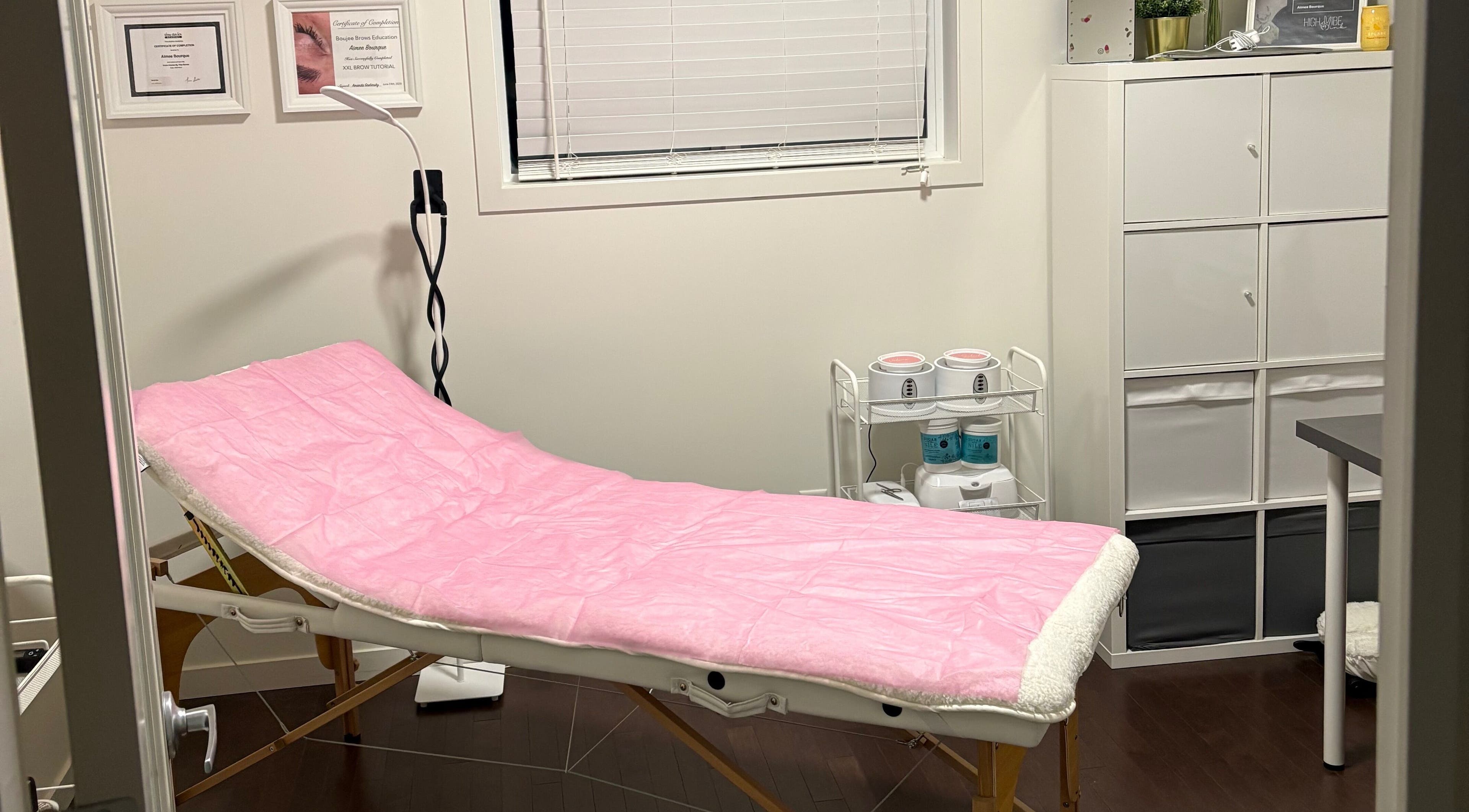 Relaxing treatment room at Chi Beauty by Aimee in Calgary, Alberta, CA, featuring a pink-covered spa bed.