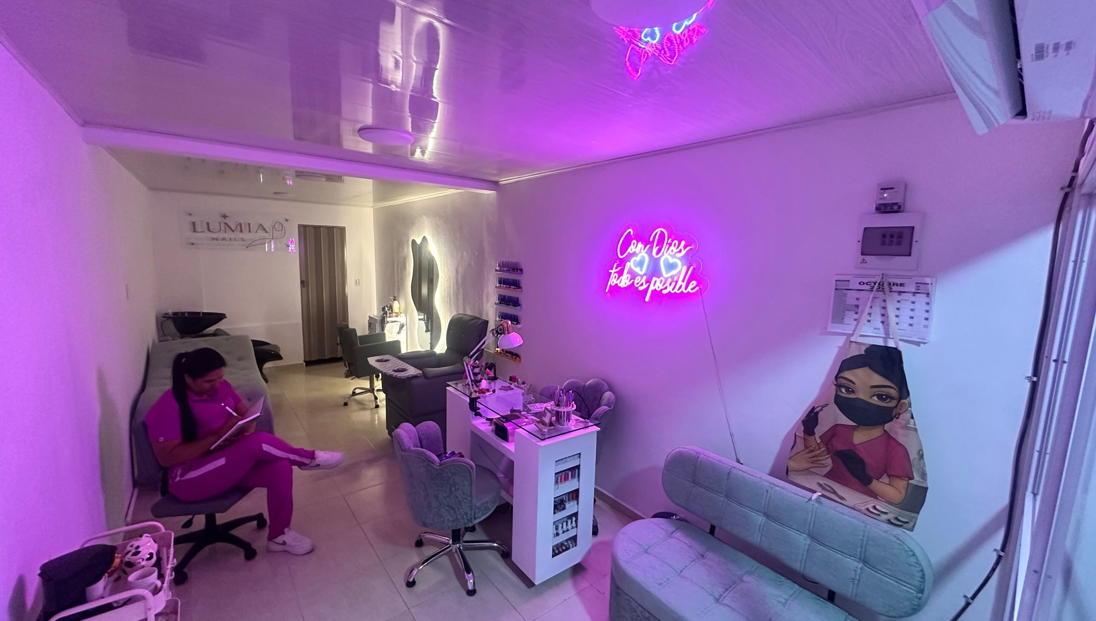 Stylish interior of Lúmia_.nails in Cali, Valle Del Cauca, CO with neon lights and cozy seating areas.