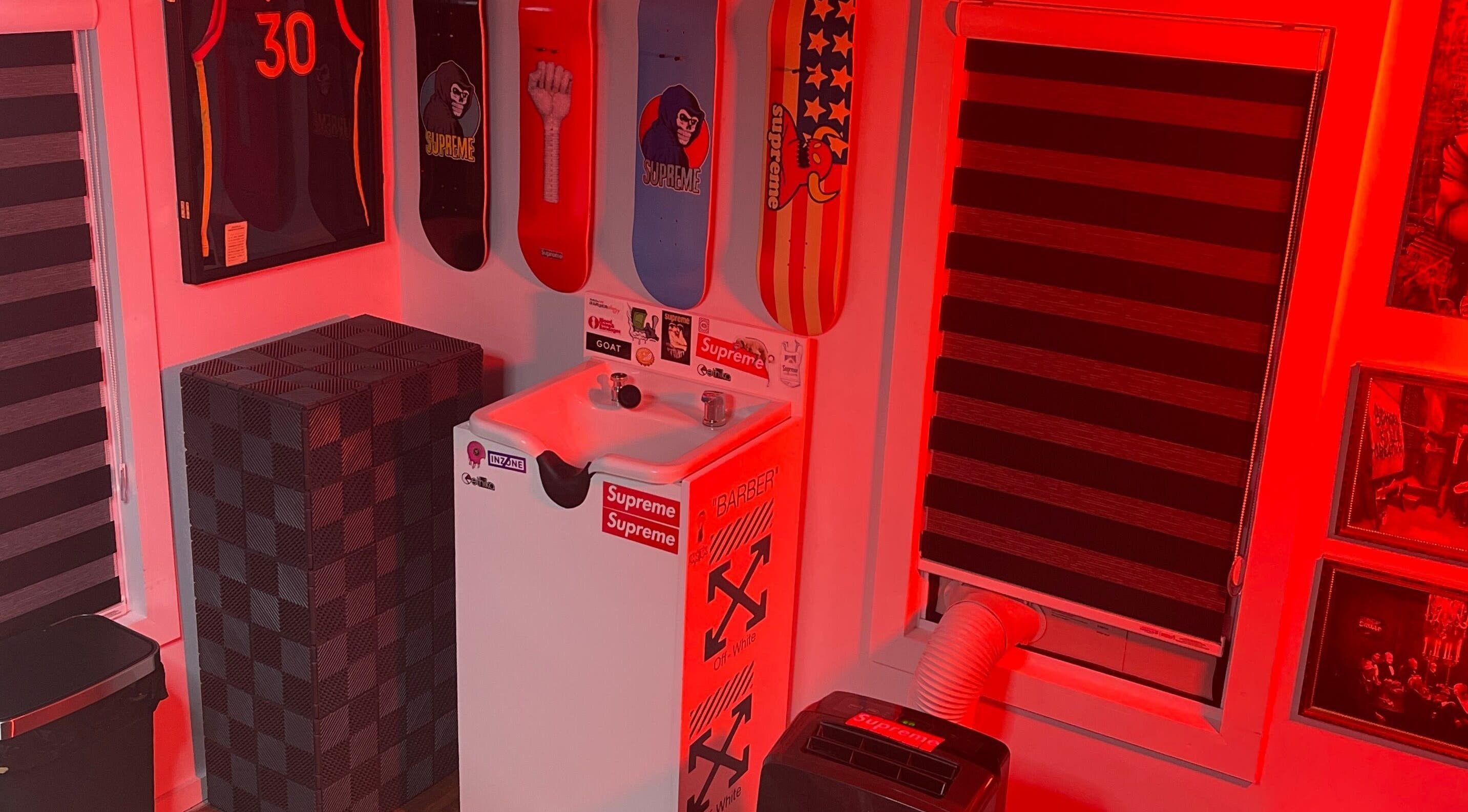 Ricktbarber sink area in Springfield, Massachusetts, US with skateboard decks and red lighting.