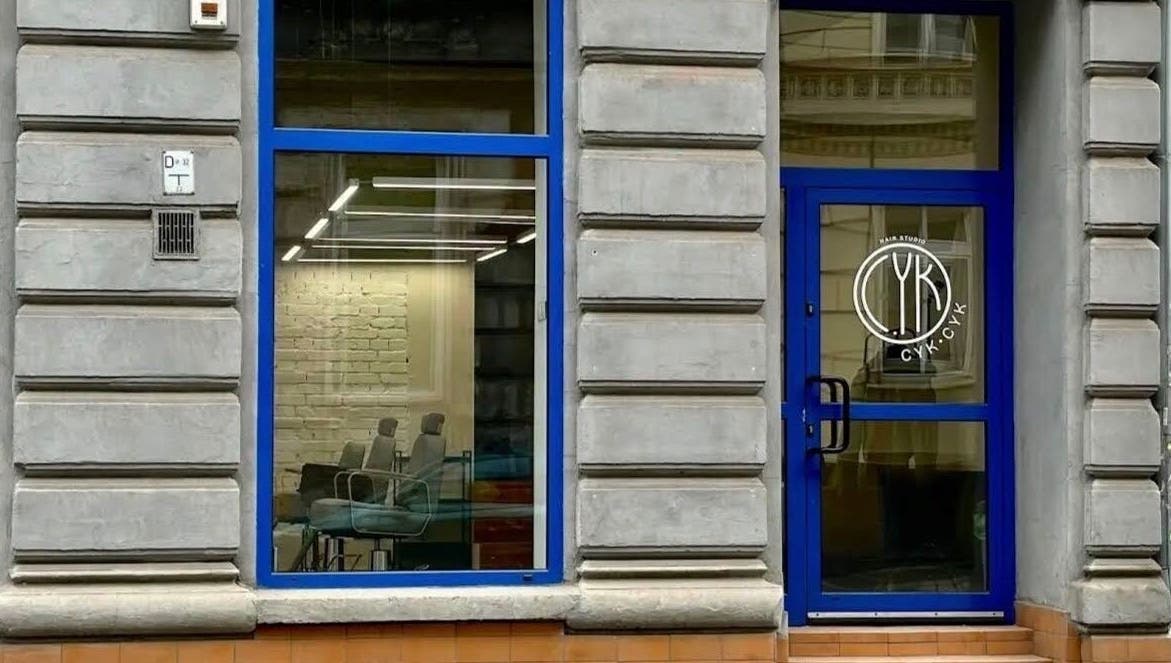 Фасад BARBER ARTEM HAVRILOV в Вроцлаве, Województwo Dolnośląskie, PL с синими окнами и дверью.