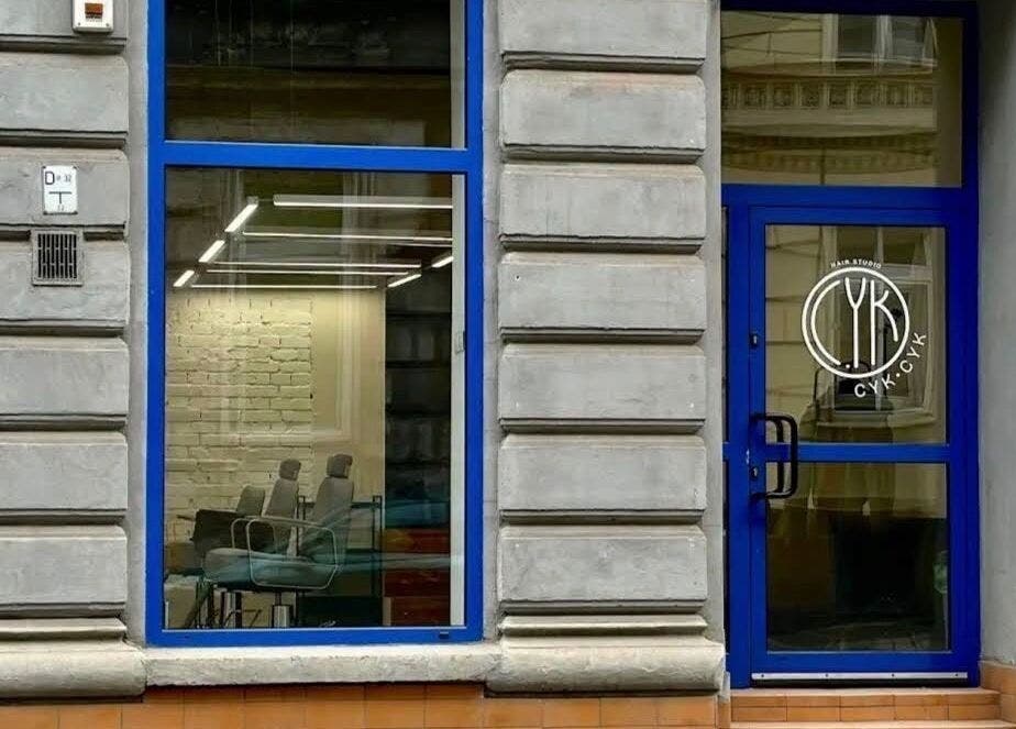 Фасад BARBER ARTEM HAVRILOV в Вроцлаве, Województwo Dolnośląskie, PL с синими окнами и дверью.