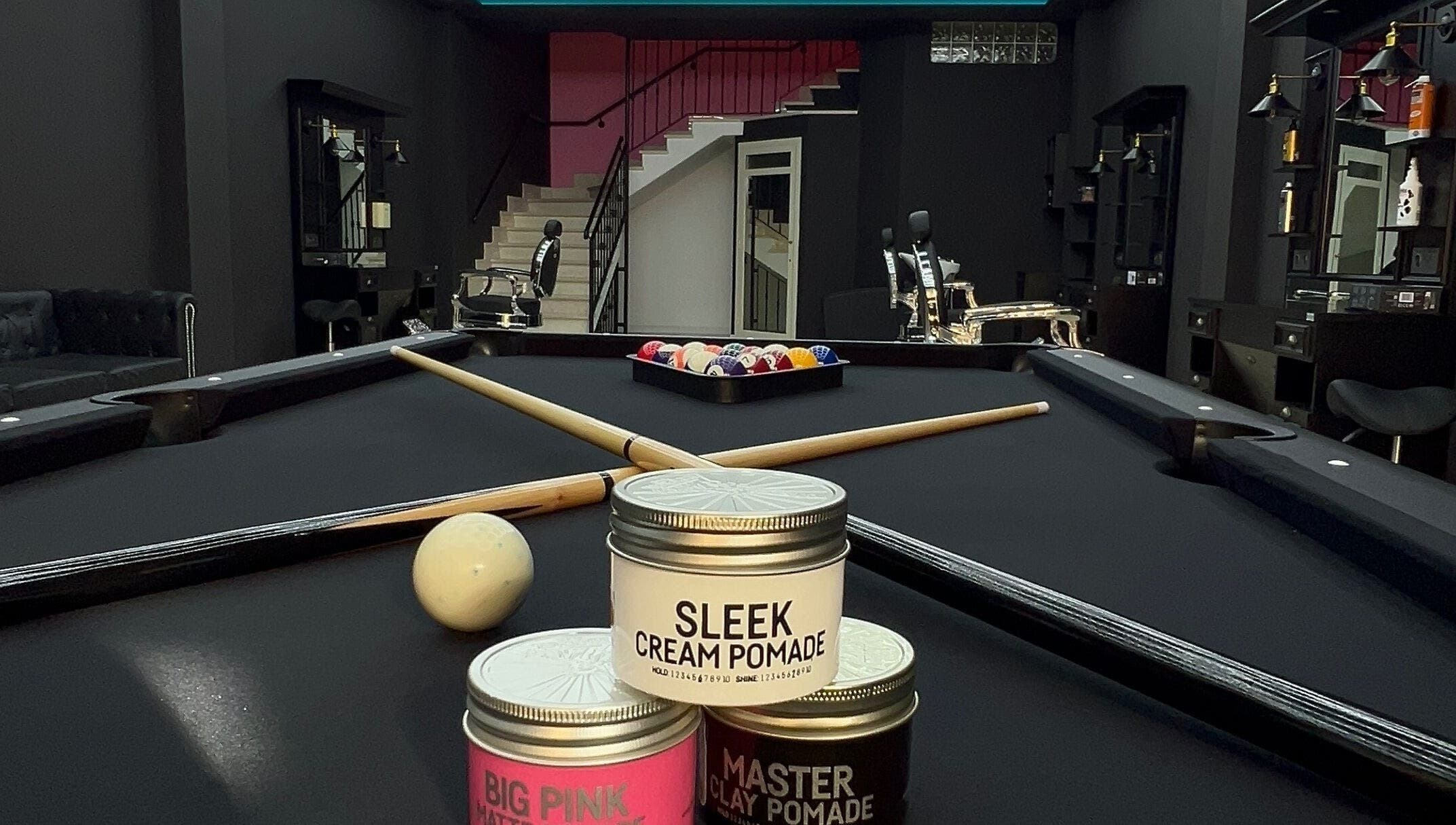 Interno di THE BARBER WOMAN a Sava, Puglia, con biliardo e prodotti per capelli.