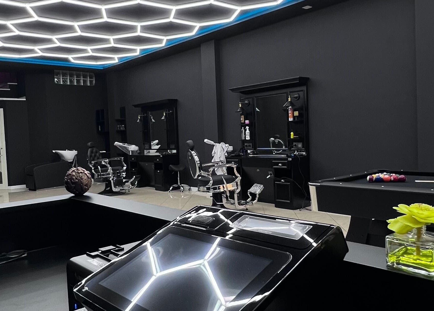 Salone moderno di THE BARBER WOMAN a Sava, Puglia, IT, con arredi eleganti e illuminazione sofisticata.