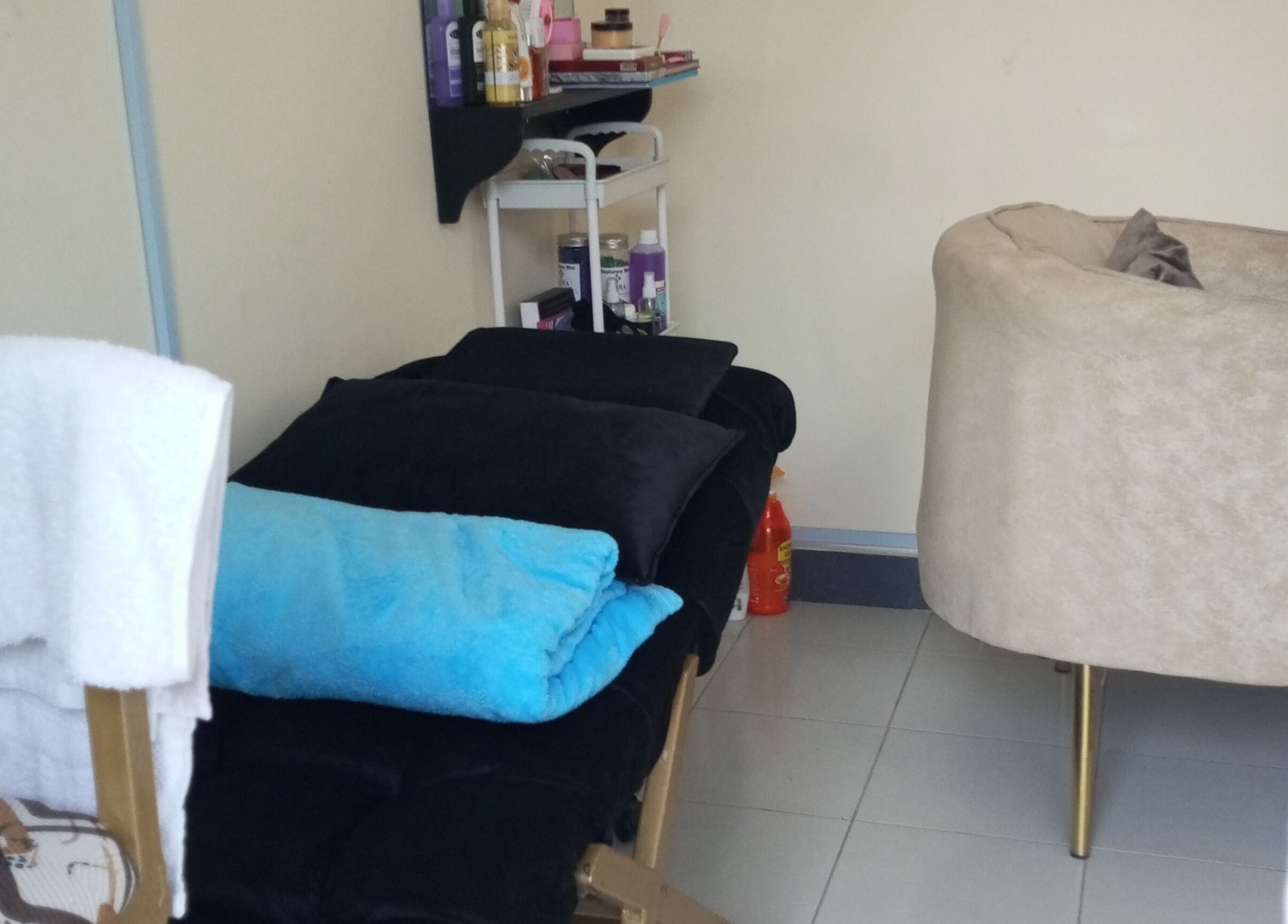 Relaxing treatment room at Kibali Glam Space in Nairobi, Nairobi County, KE with plush seating and soft towels.