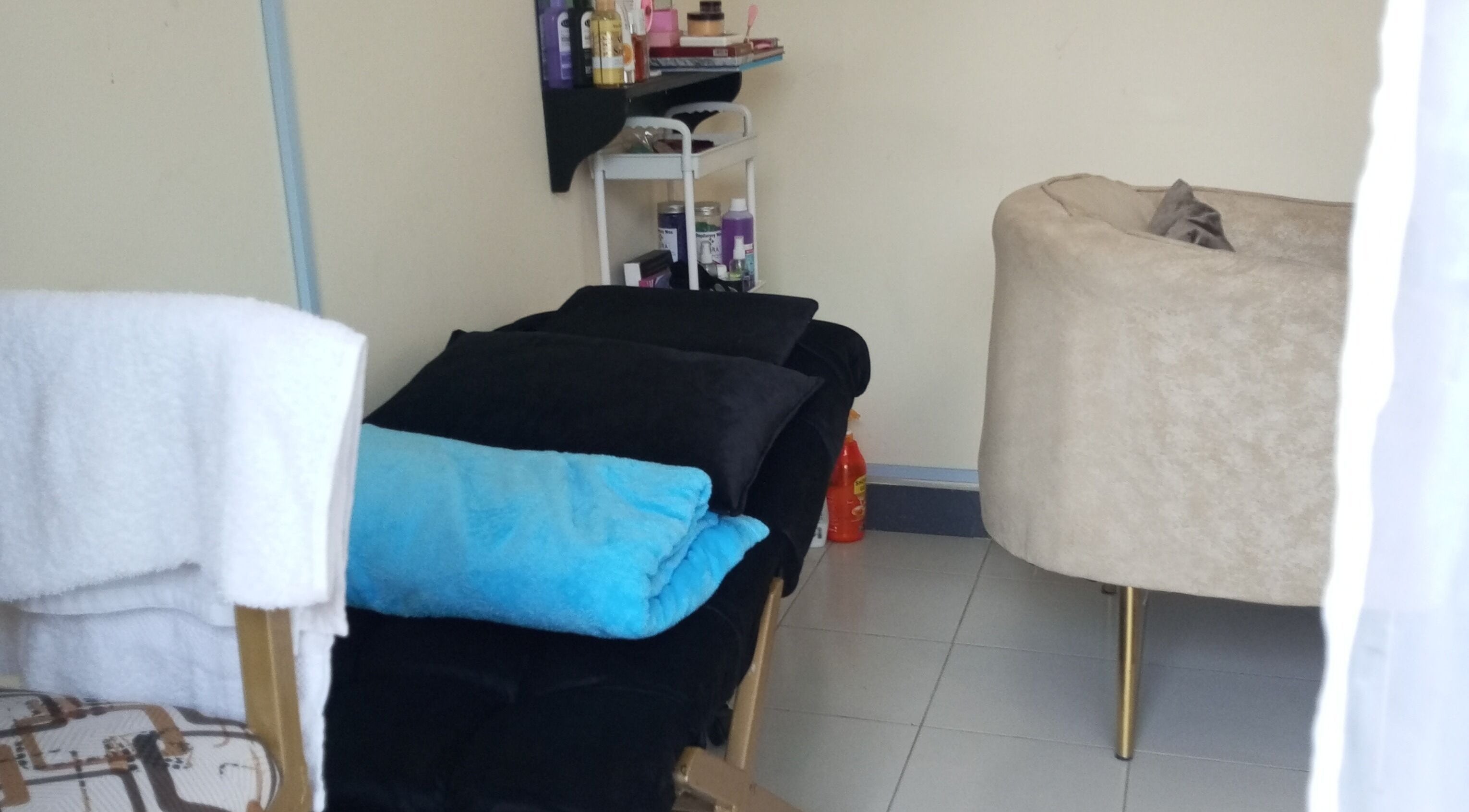 Relaxing treatment room at Kibali Glam Space in Nairobi, Nairobi County, KE with plush seating and soft towels.