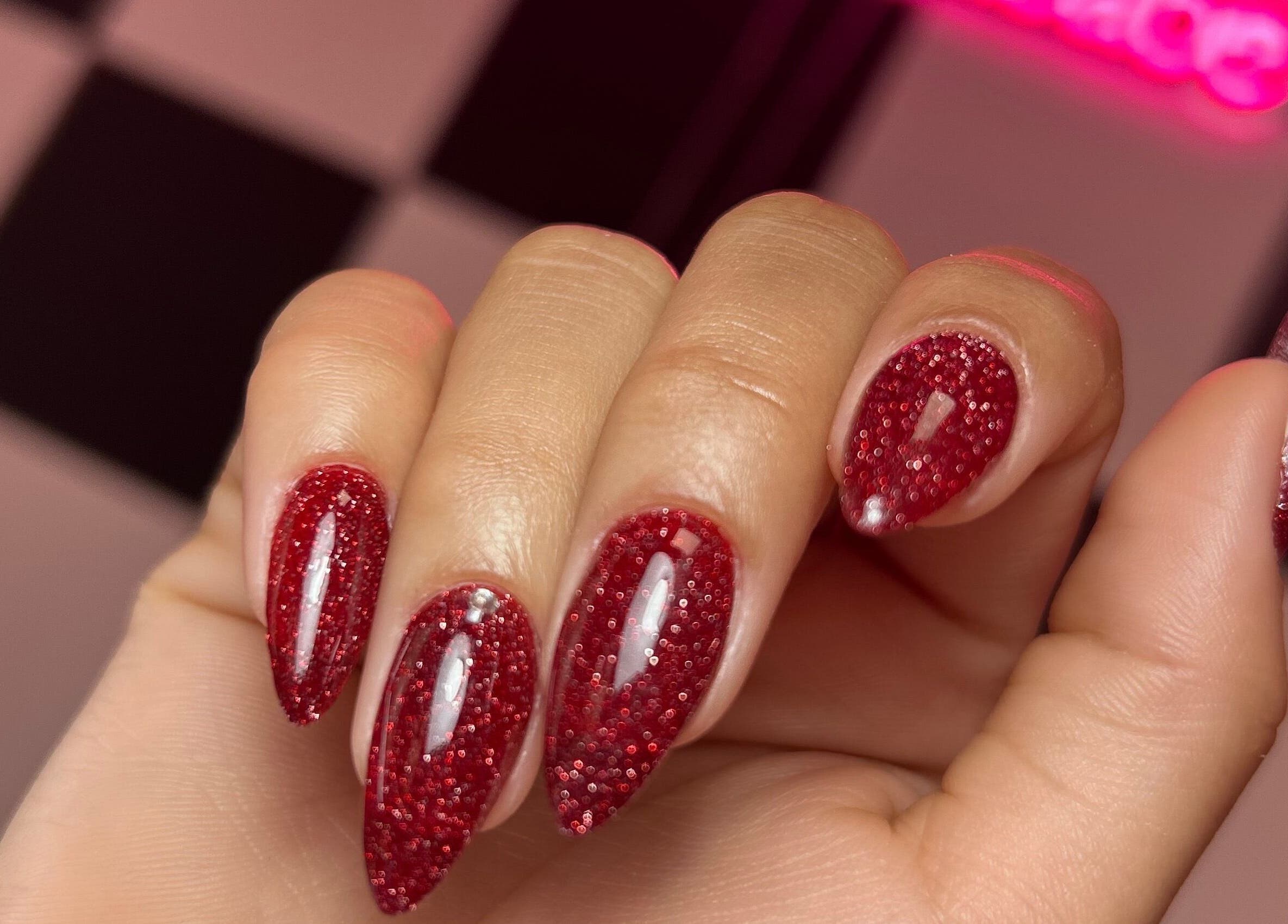 Sparkling red glitter nails design at Beautybarbygeopr, Vega Alta, PR, showcasing elegant nail artistry.
