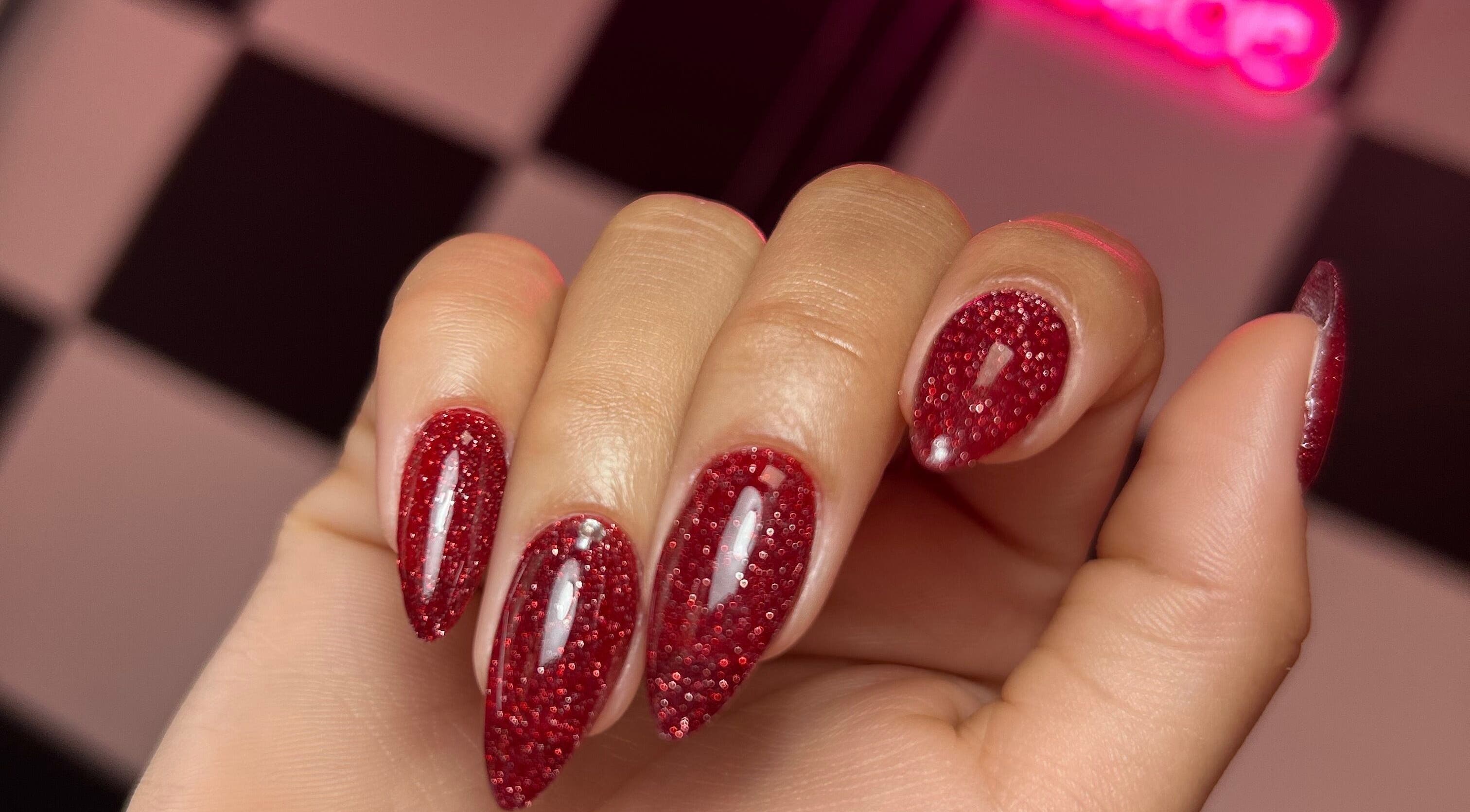 Sparkling red glitter nails design at Beautybarbygeopr, Vega Alta, PR, showcasing elegant nail artistry.