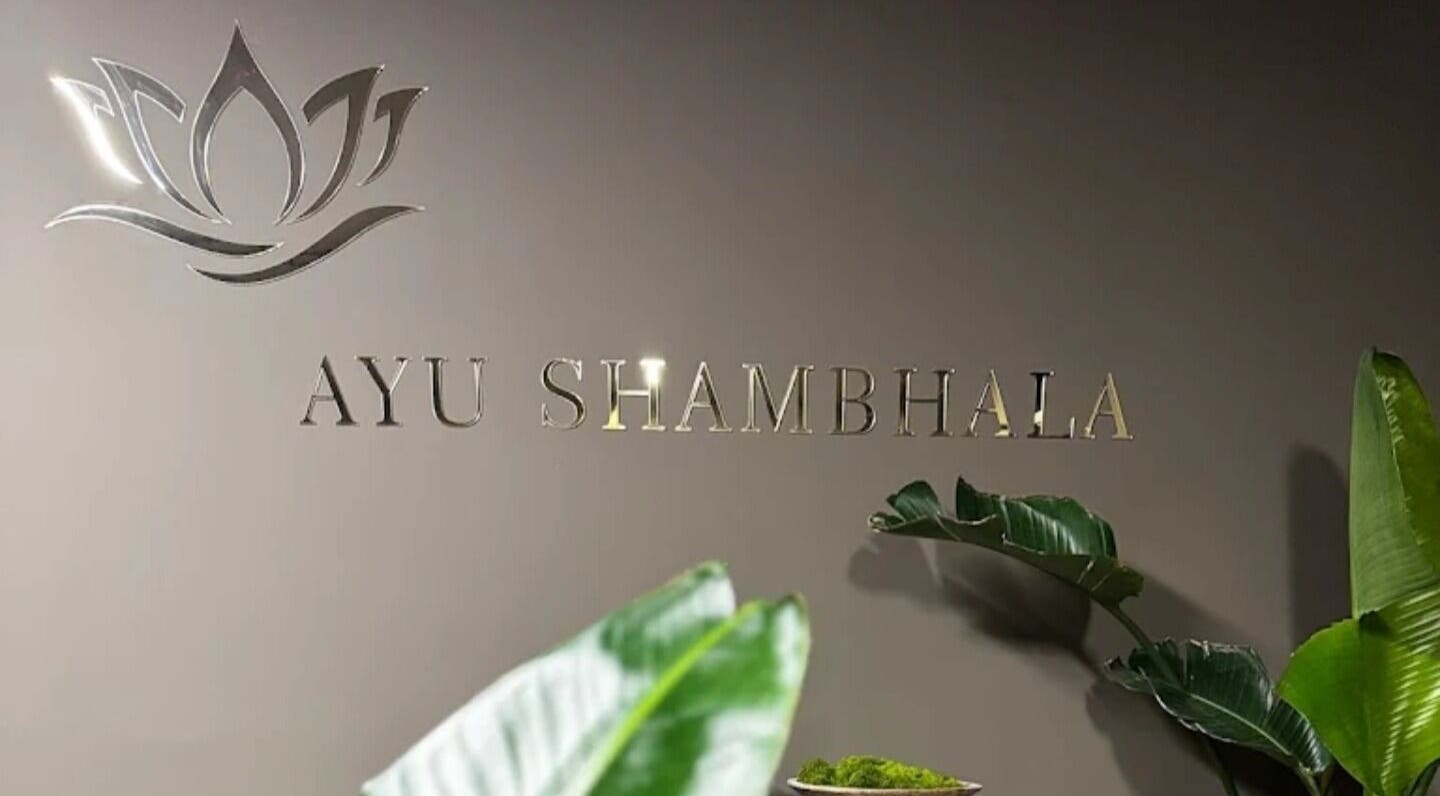 Ayu Shambhala entrance with elegant signage and plants in Łódź, Województwo Łódzkie, PL.