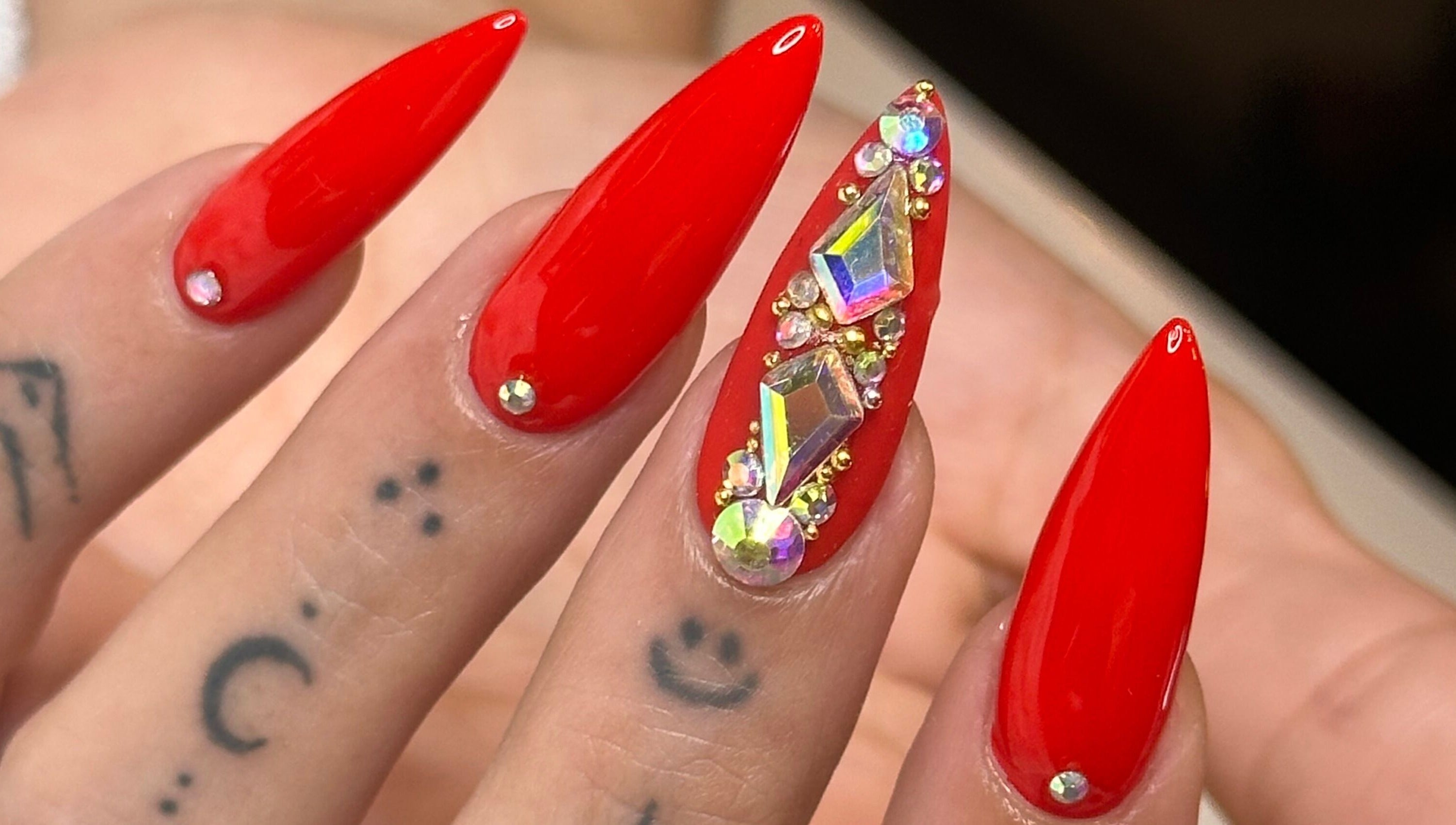 Elegant red stiletto nails with gems at Tip To Toe Beauty Salon, Paramaribo, Paramaribo, SR.