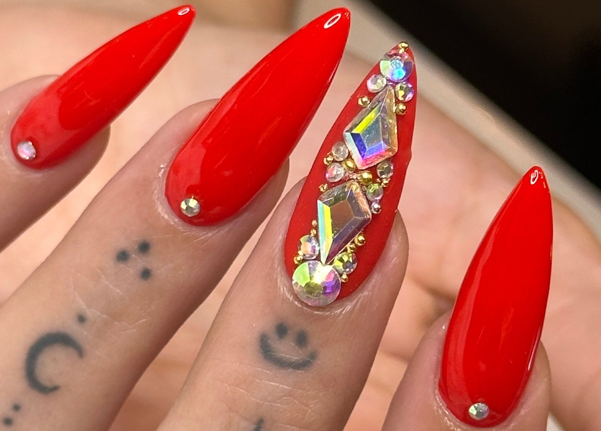 Elegant red stiletto nails with gems at Tip To Toe Beauty Salon, Paramaribo, Paramaribo, SR.