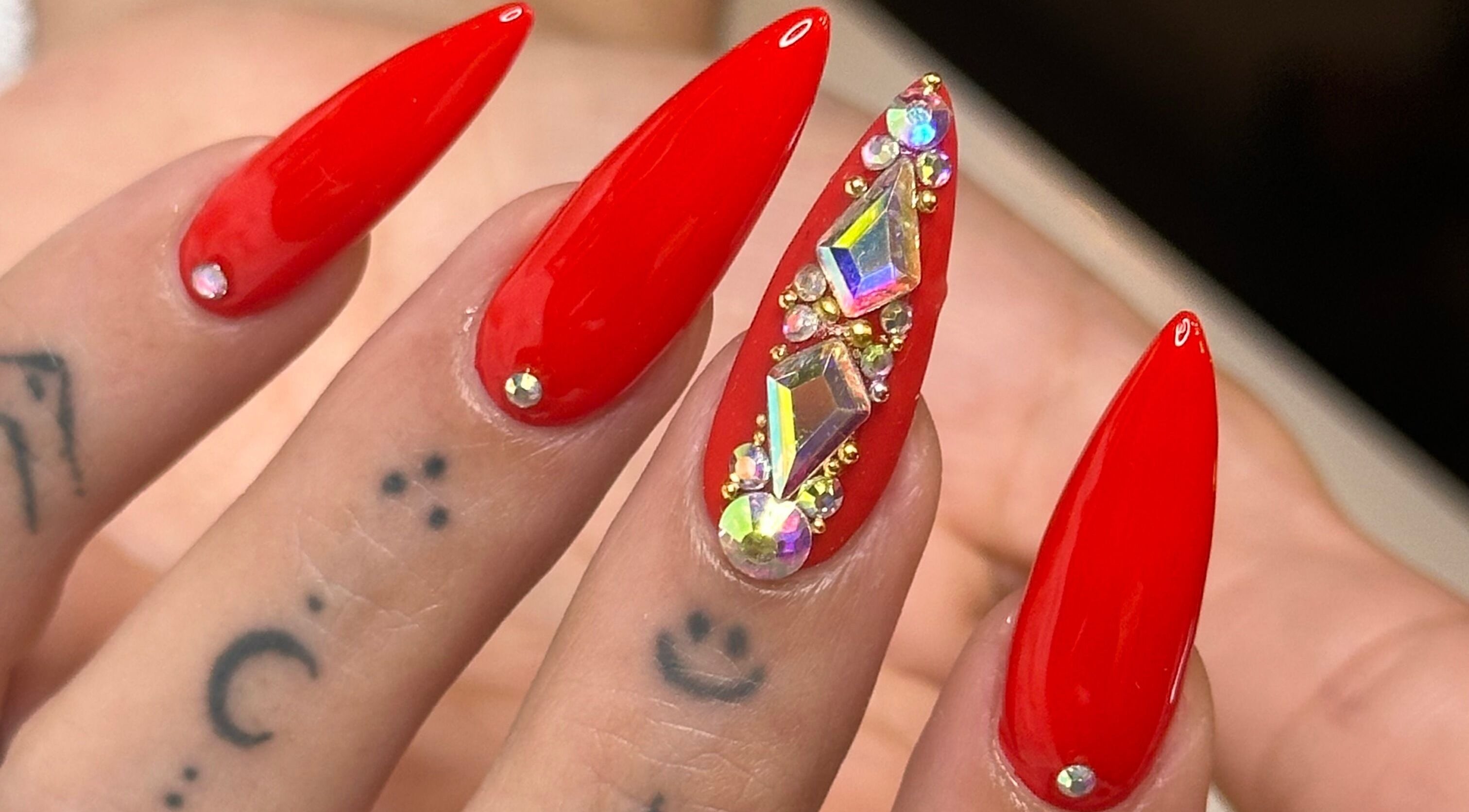 Elegant red stiletto nails with gems at Tip To Toe Beauty Salon, Paramaribo, Paramaribo, SR.