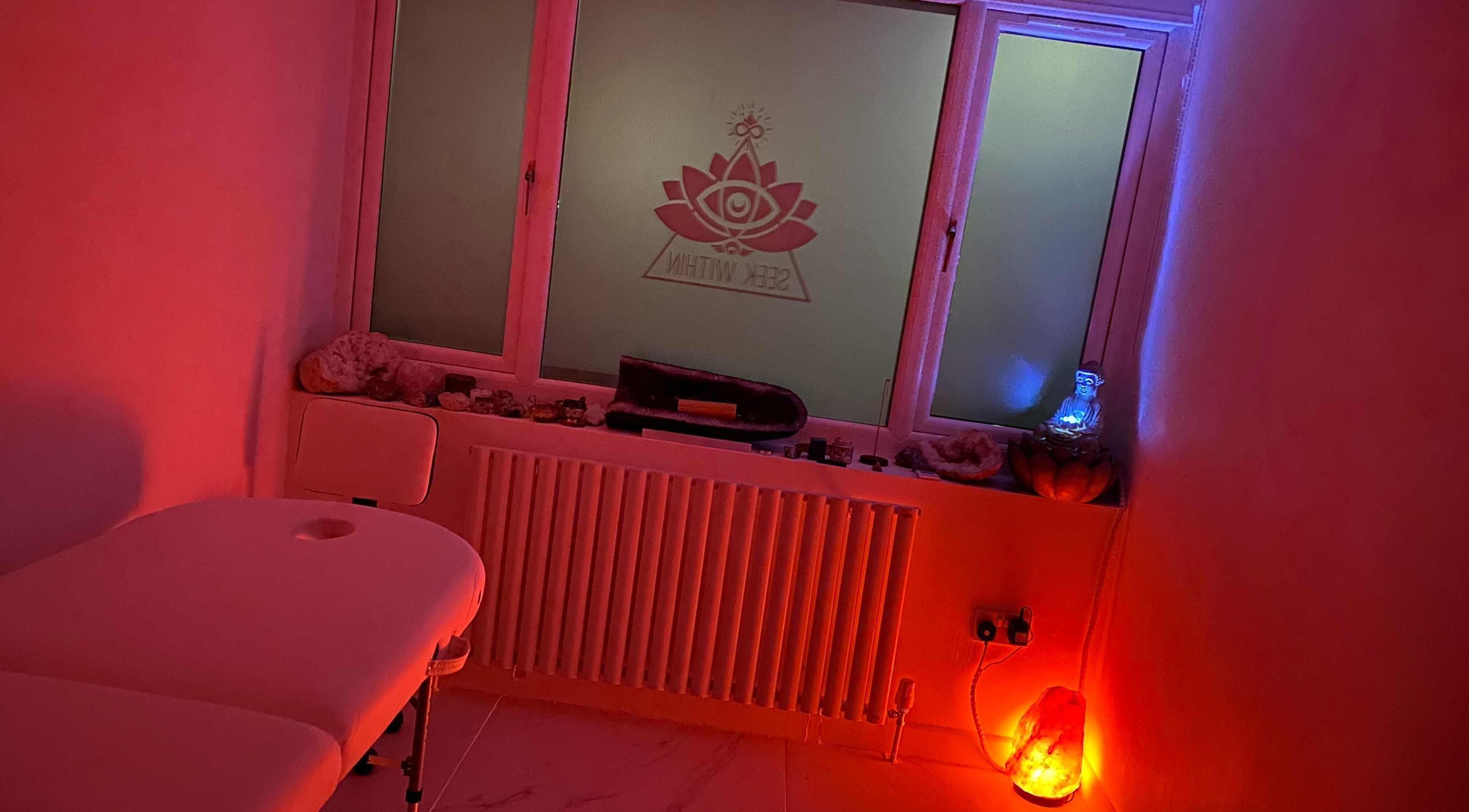 Tranquil massage room at Seek Within, Walsall, England, GB, with calming red lighting and peaceful decor.