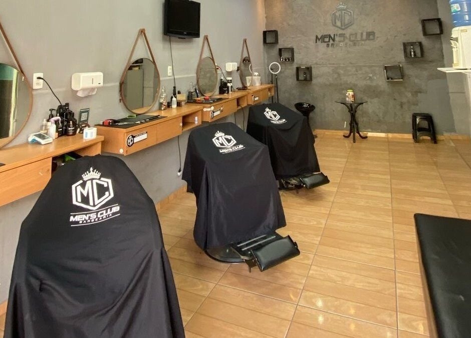 Interior da barbearia Mensclub em Espírito Santo, Espírito Santo, BR com cadeiras modernas e espelhos elegantes.