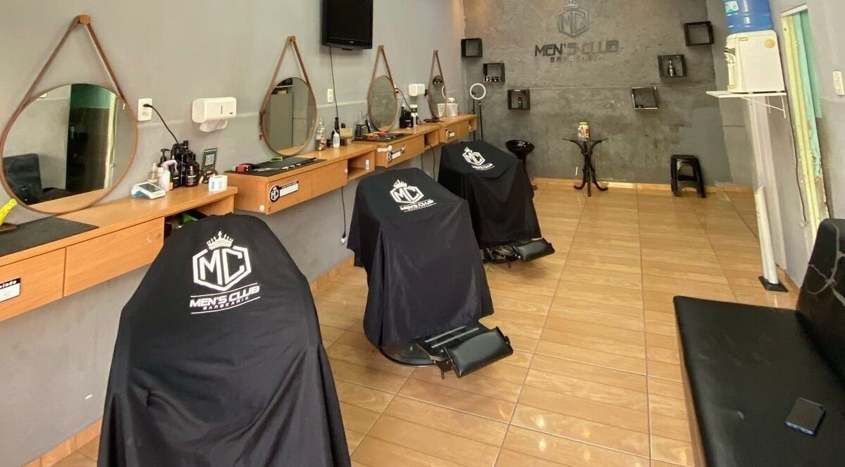 Interior da barbearia Mensclub em Espírito Santo, Espírito Santo, BR com cadeiras modernas e espelhos elegantes.