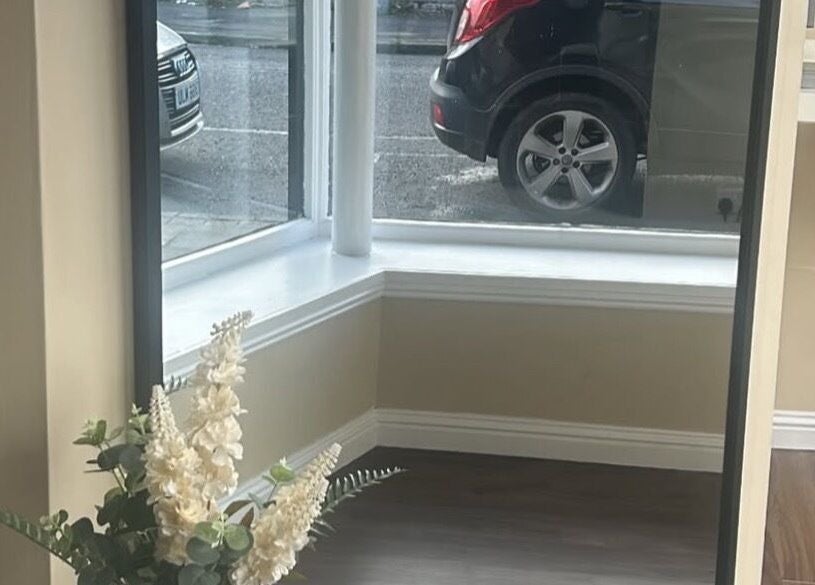 Chic corner with window, mirror, and flowers at Hair by Casey, Edinburgh, Scotland, GB.