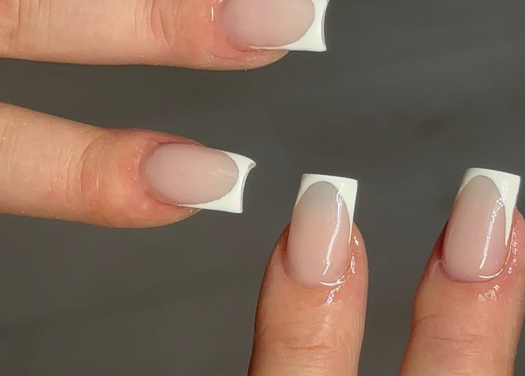 Elegant French tip manicure at Nailedbylaurinda, Birmingham, England, GB, showcasing glossy and neat nail art.