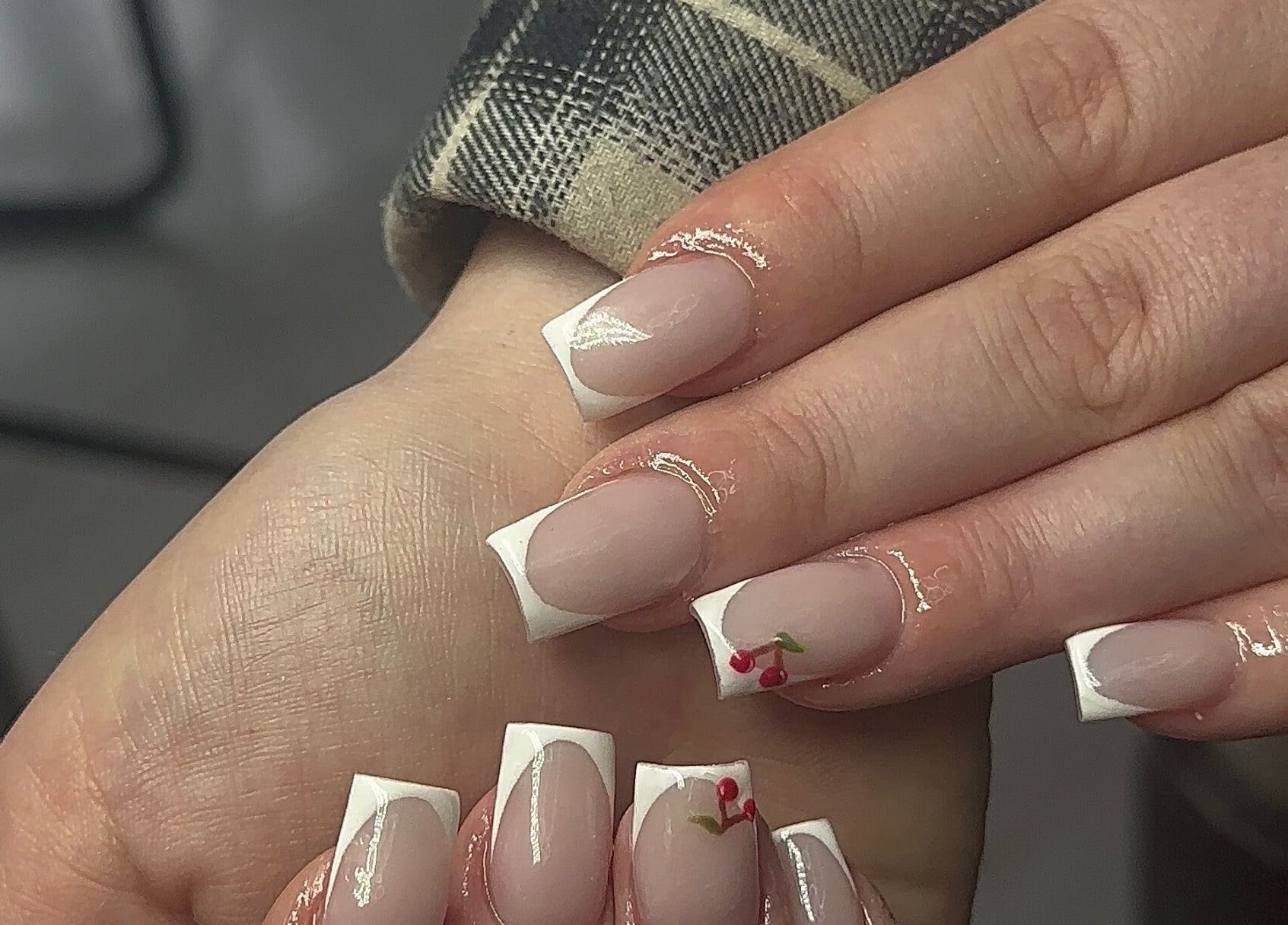 Elegant French manicure with cherry art at Nailedbylaurinda in Birmingham, England, GB.
