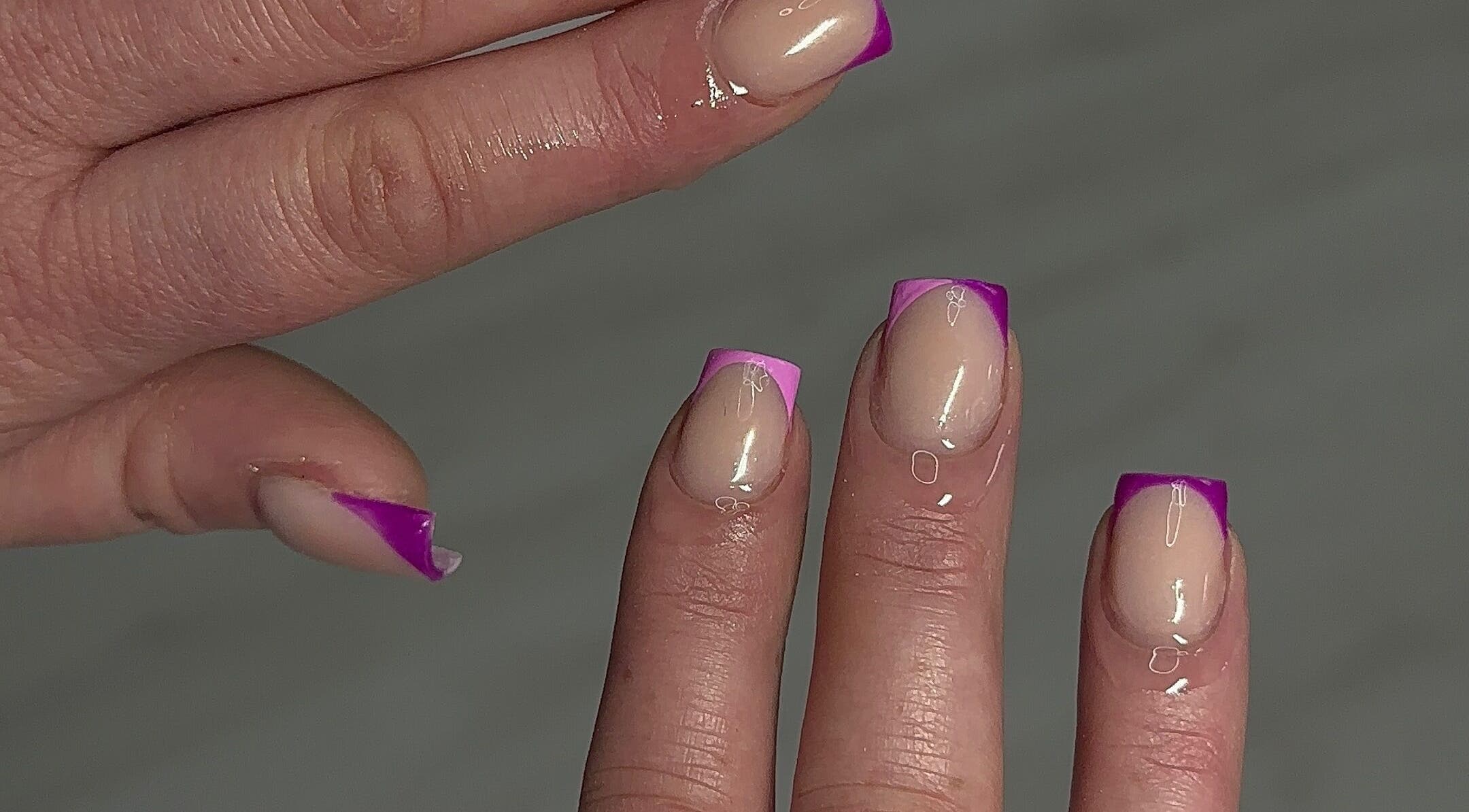 Close-up of purple-tipped nails at Nailedbylaurinda, Birmingham, England, GB showcasing stylish manicure.