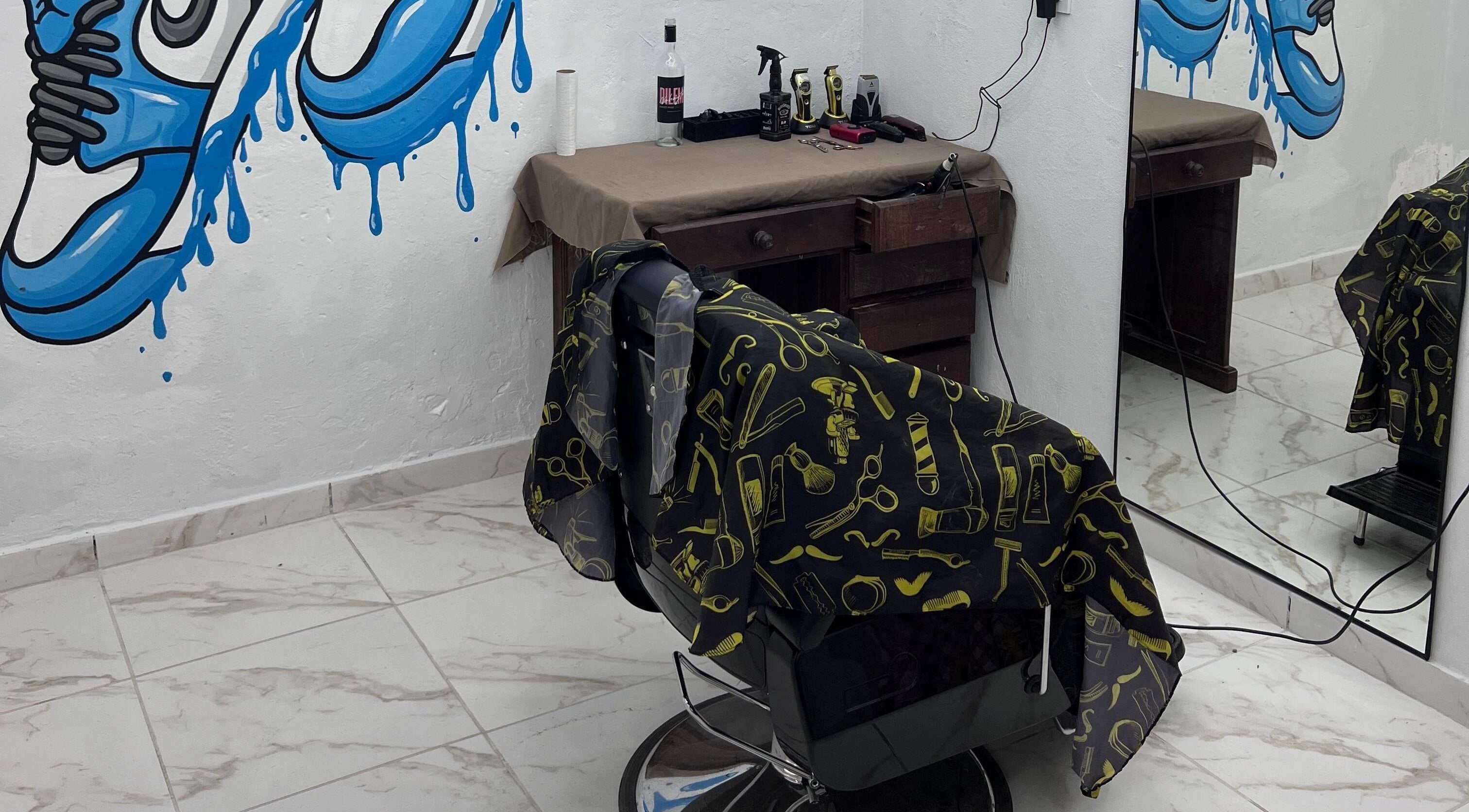 Interior de Hood Barbershop en Villa Gobernador Galvez, Santa Fe; silla de barbero y decoraciones llamativas.