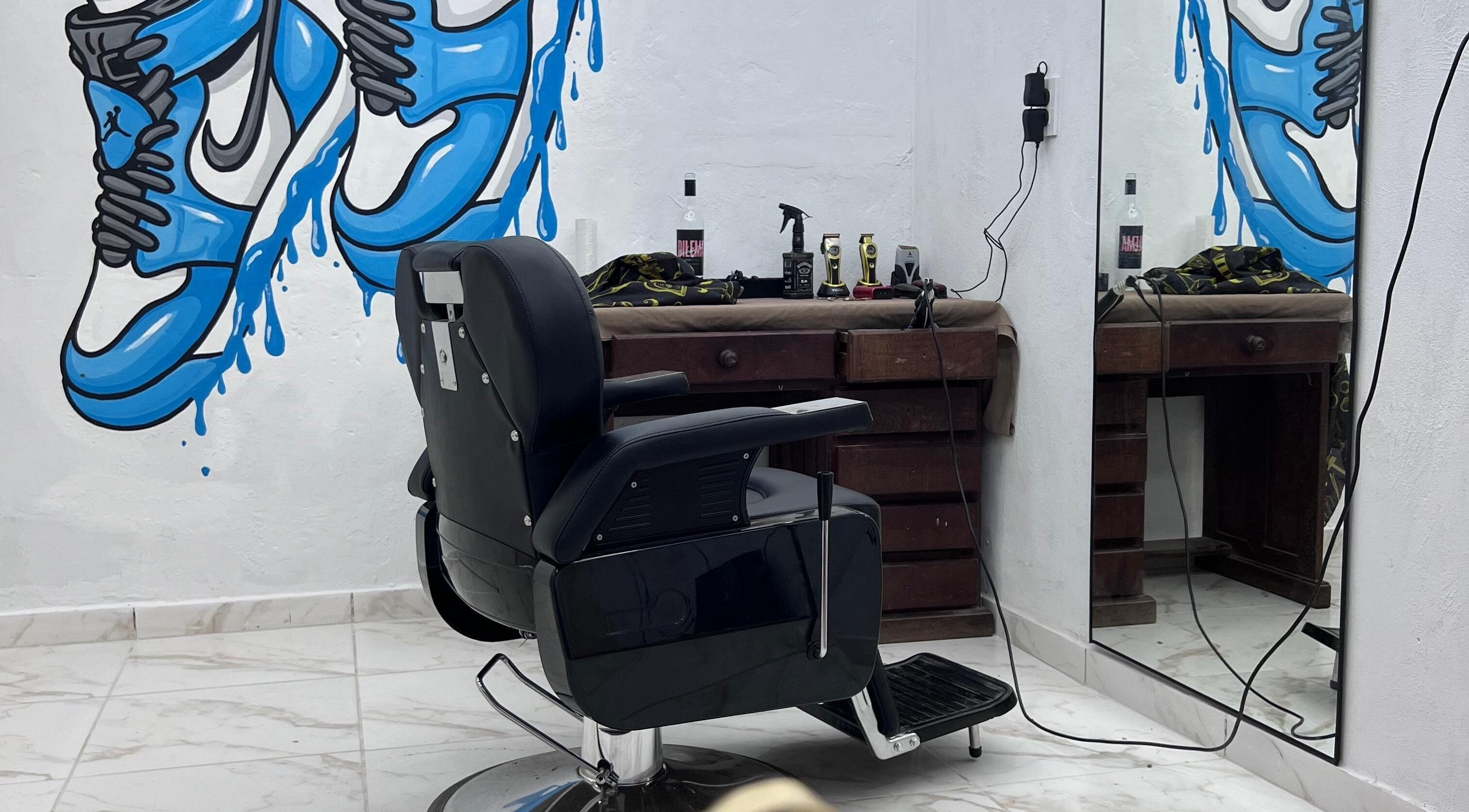 Interior de Hood Barbershop en Villa Gobernador Galvez, Santa Fe, AR con mural vibrante y silla de barbero clásica.