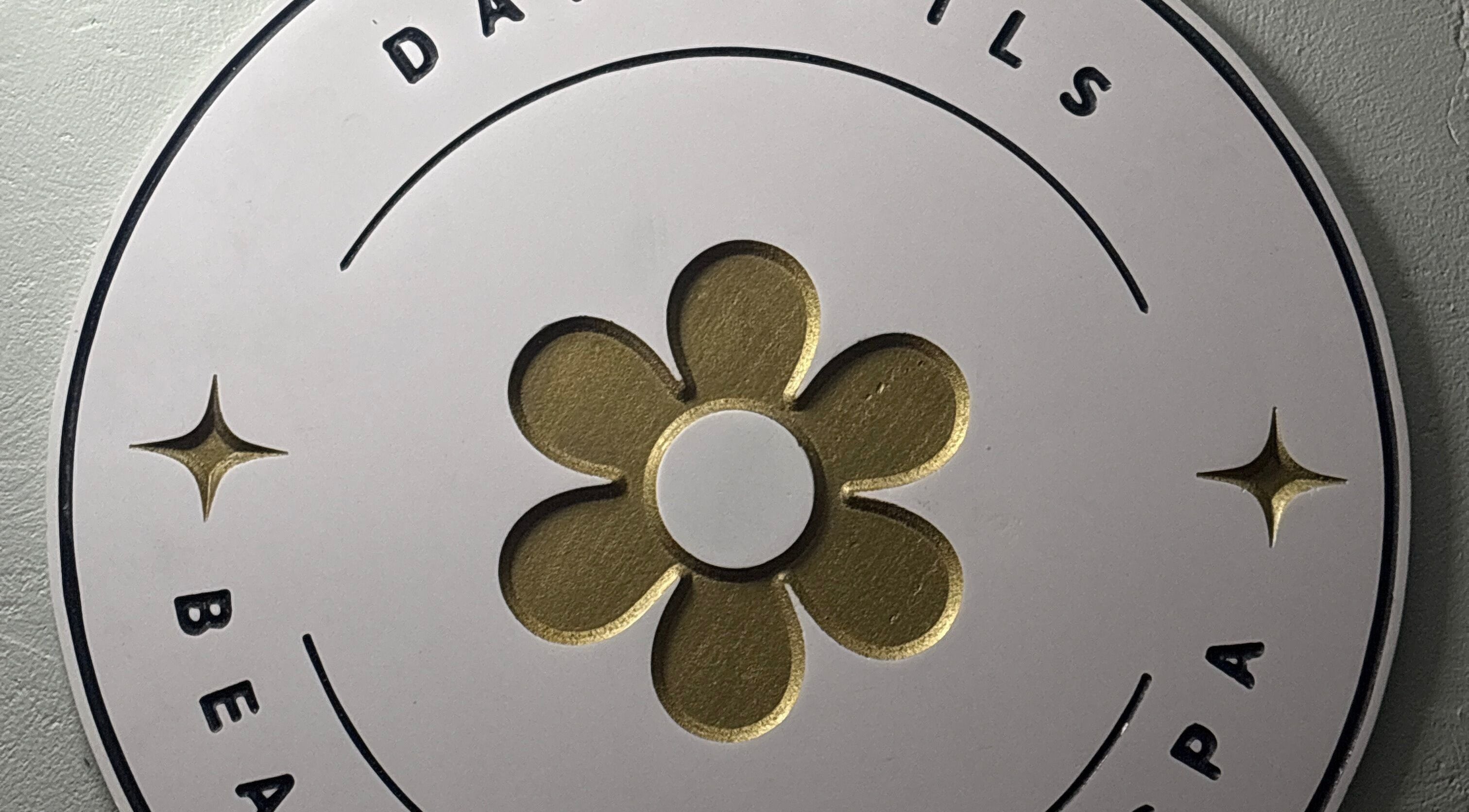 Logo of daffodils beauty salon & spa in Basseterre, Saint George Basseterre Parish, KN with gold flower design.