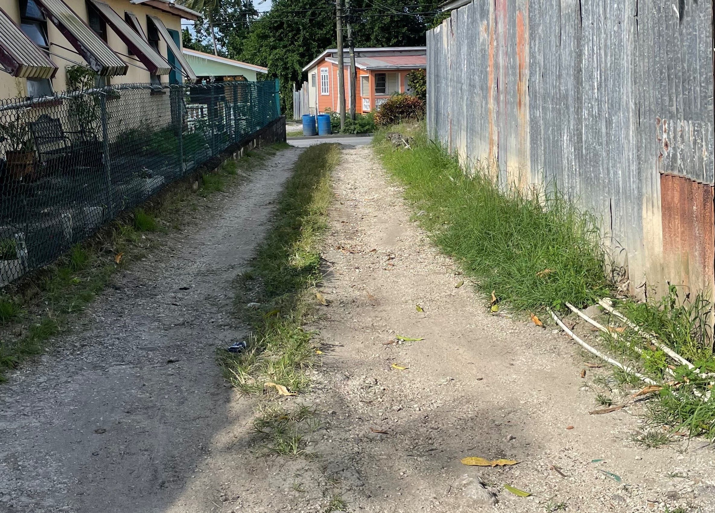 Rustic pathway leading to The Luxe Nail Art Studio in Bridgetown, Saint Michael, BB, showcasing local charm.