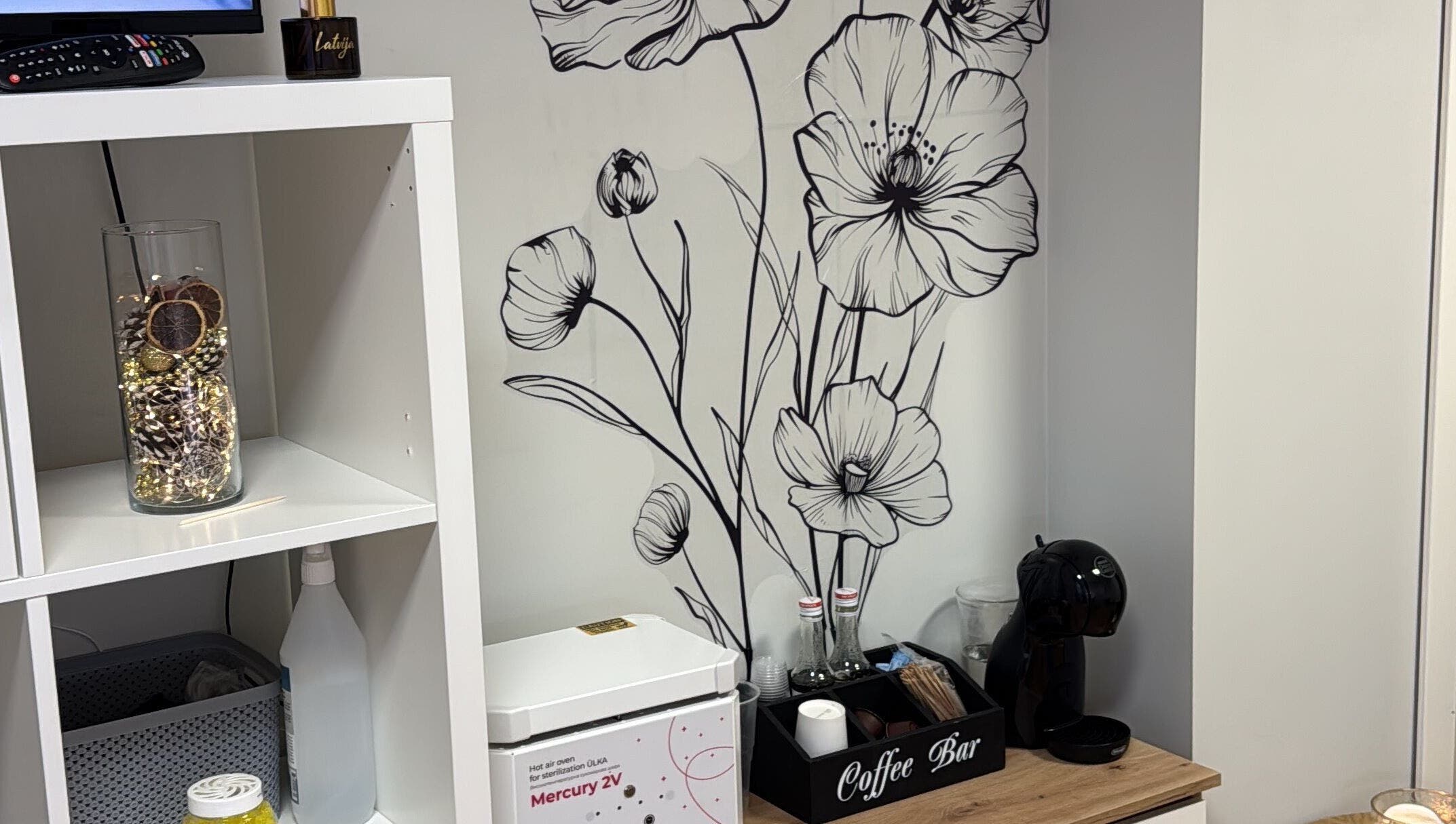 Элегантный дизайн стен в Kireile_nails, Рига, LV, с черными цветами и чайной зоной.