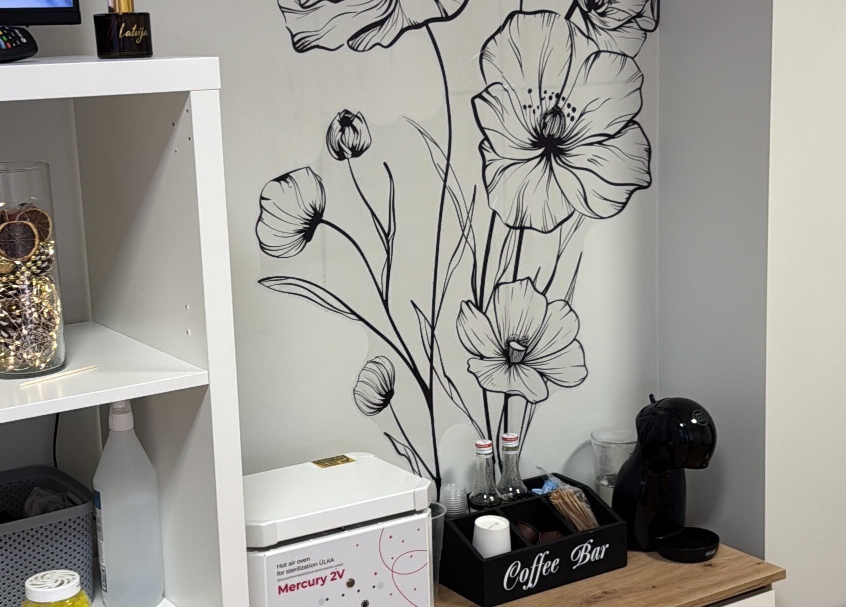 Элегантный дизайн стен в Kireile_nails, Рига, LV, с черными цветами и чайной зоной.