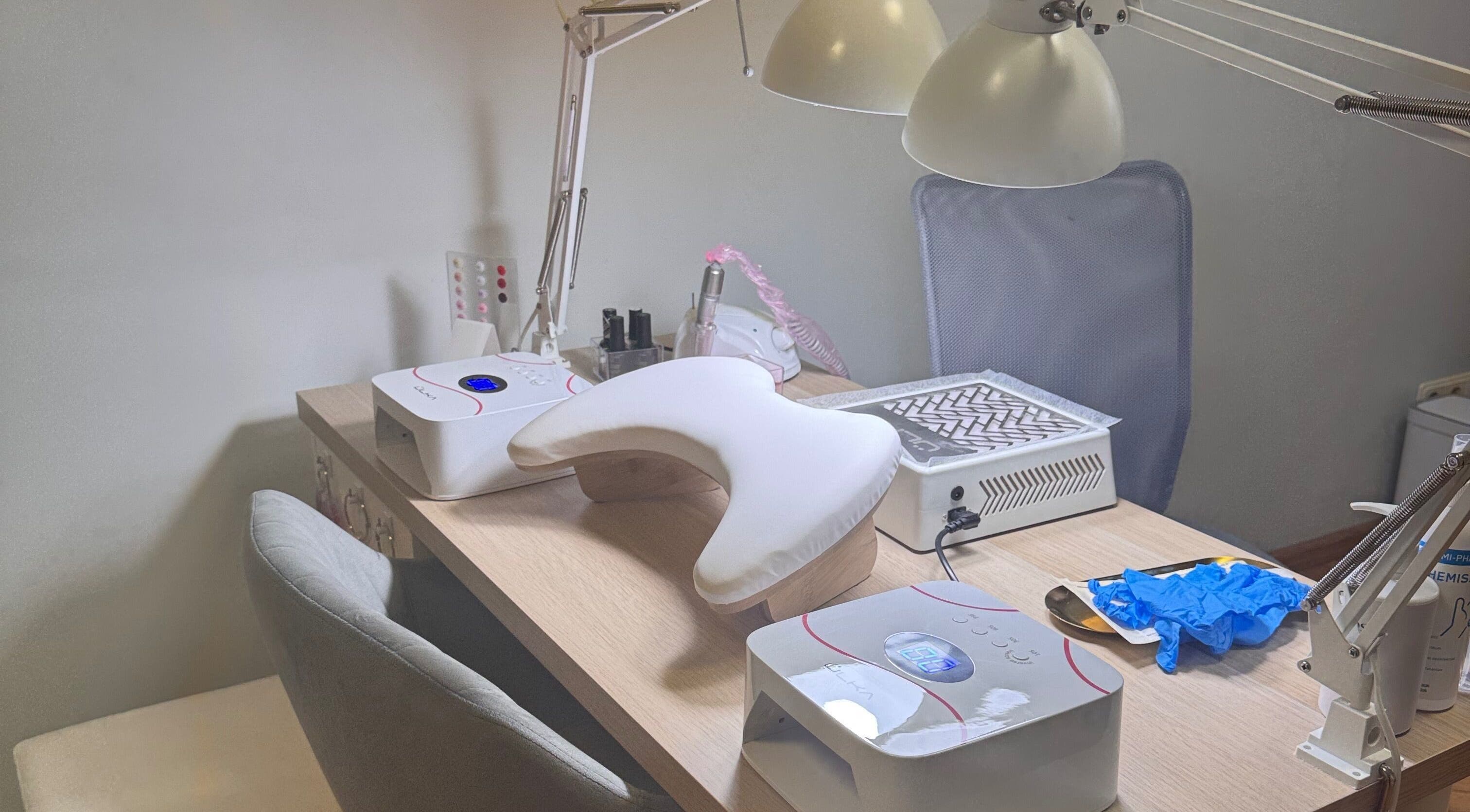 Маникюрный стол в Kireile Nails, Рига, LV с инструментами и лампами для ногтей.