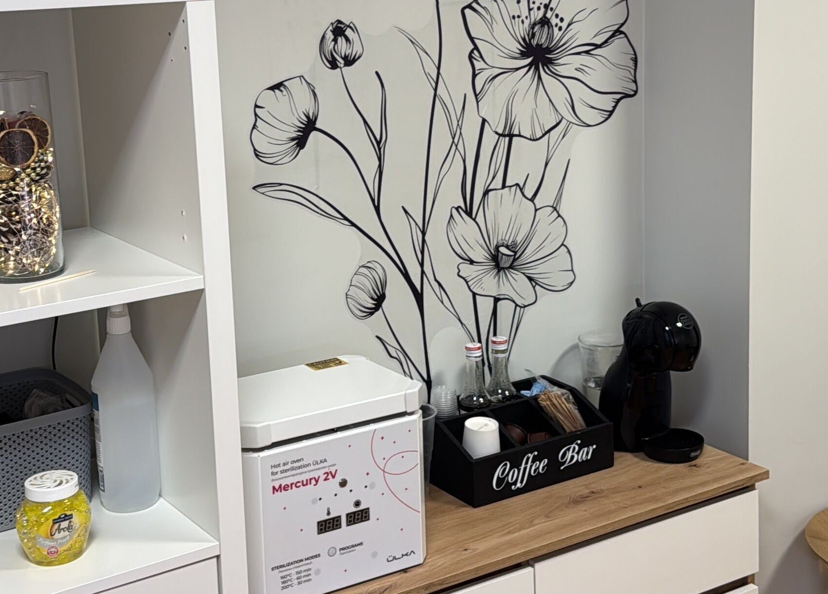 Уголок с кофеваркой и декором в Kireile Nails, Рига, LV, создаёт уютную атмосферу.