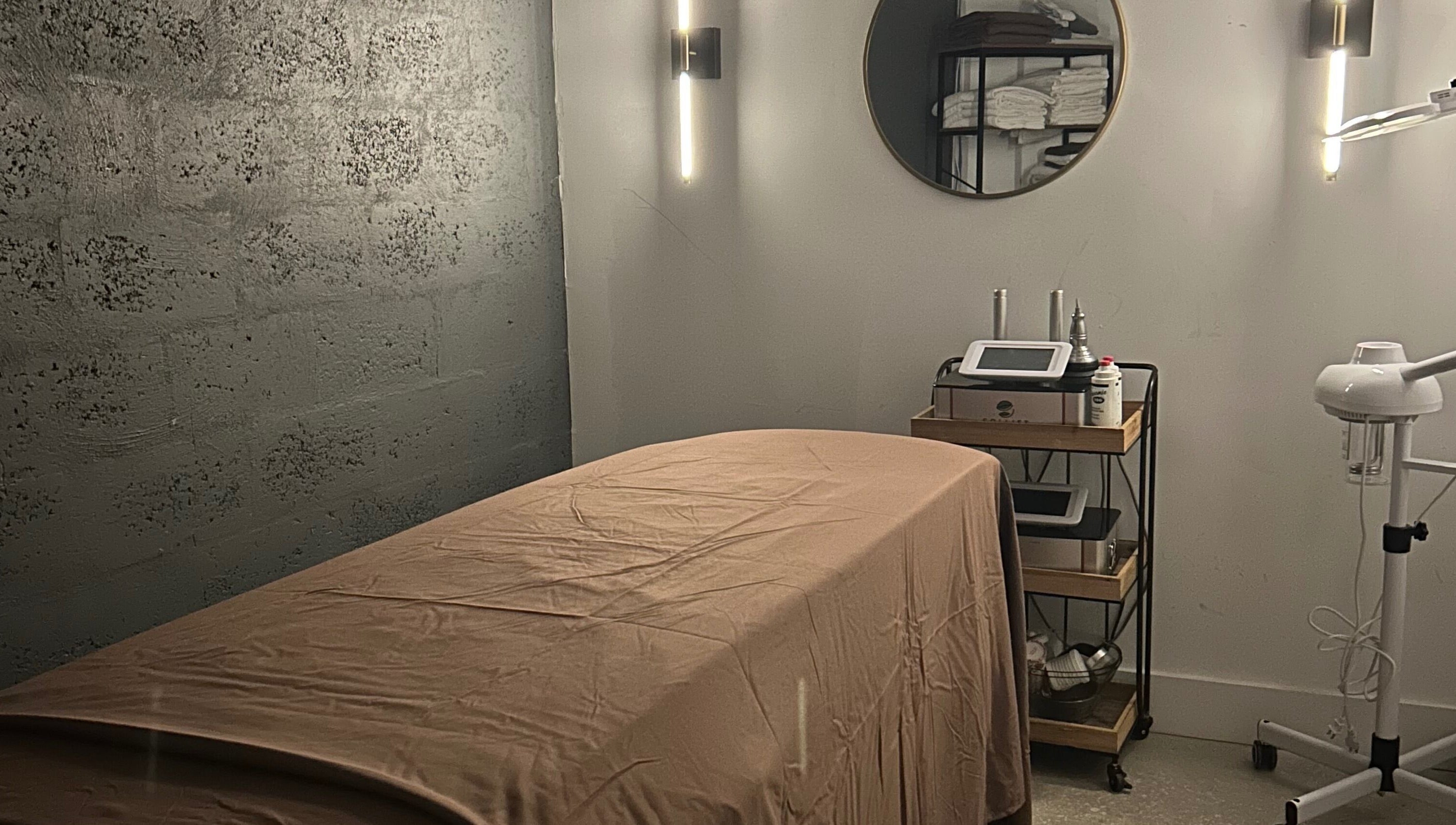 Calm spa room at Voilá Esti Lab in Fort Lauderdale, Florida, US, with massage table and wellness equipment.
