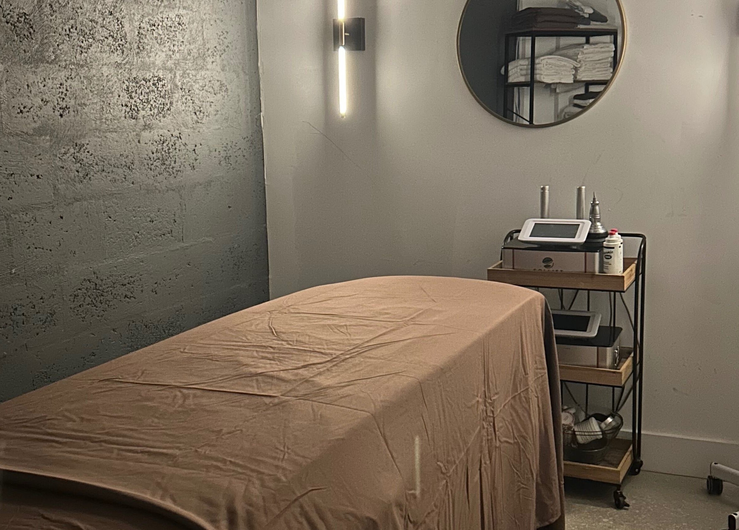 Calm spa room at Voilá Esti Lab in Fort Lauderdale, Florida, US, with massage table and wellness equipment.
