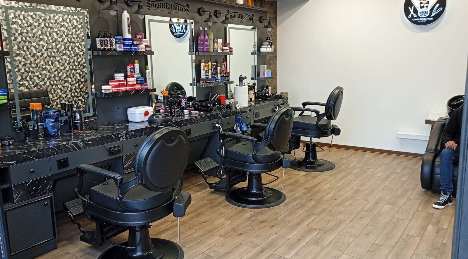 Chic barbershop inside 'Paris by Italy', Paderno Dugnano, Lombardia, IT with modern chairs and grooming products.
