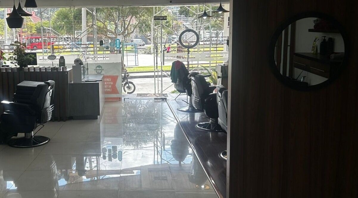 Salón elegante de D'Avila Barbería en Cuenca, Azuay, EC con sillas cómodas y vista panorámica.