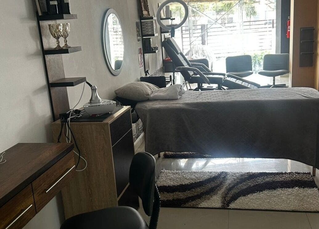 Sala acogedora en D'Avila Barbería, Cuenca, Azuay, EC, con camilla para tratamientos de belleza.