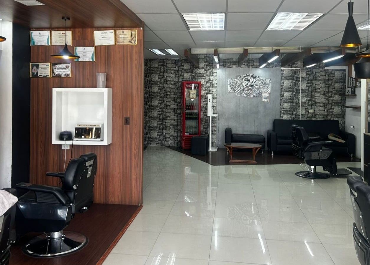 Interior moderno de D'Avila Barbería en Cuenca, Azuay, EC, con sillas elegantes y decoración contemporánea.