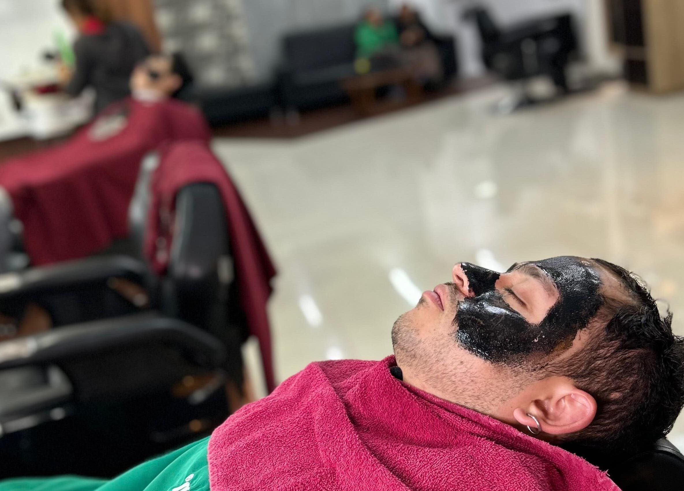 Cliente recibiendo tratamiento facial en D'Avila Barbería, Cuenca, Azuay, EC.