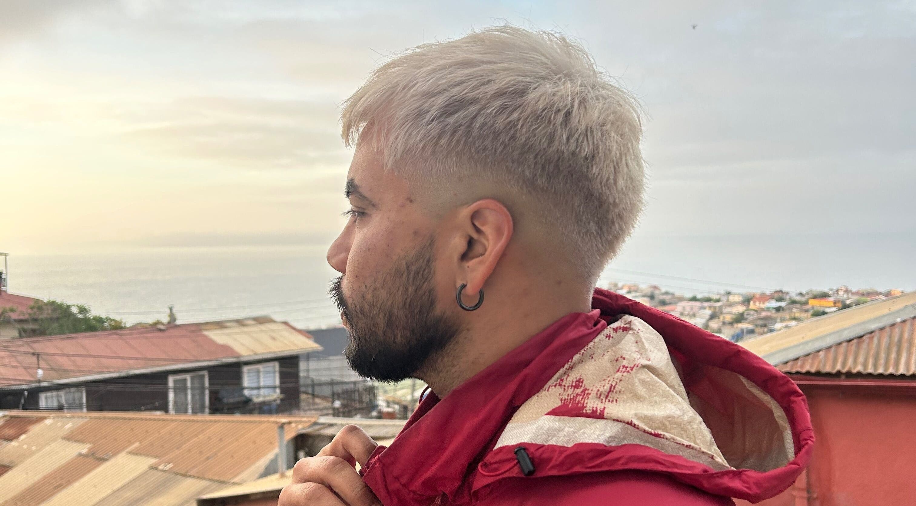 Stylish man with blond hair at Indiscretx, Valparaíso, Valparaíso, CL with a coastal view.