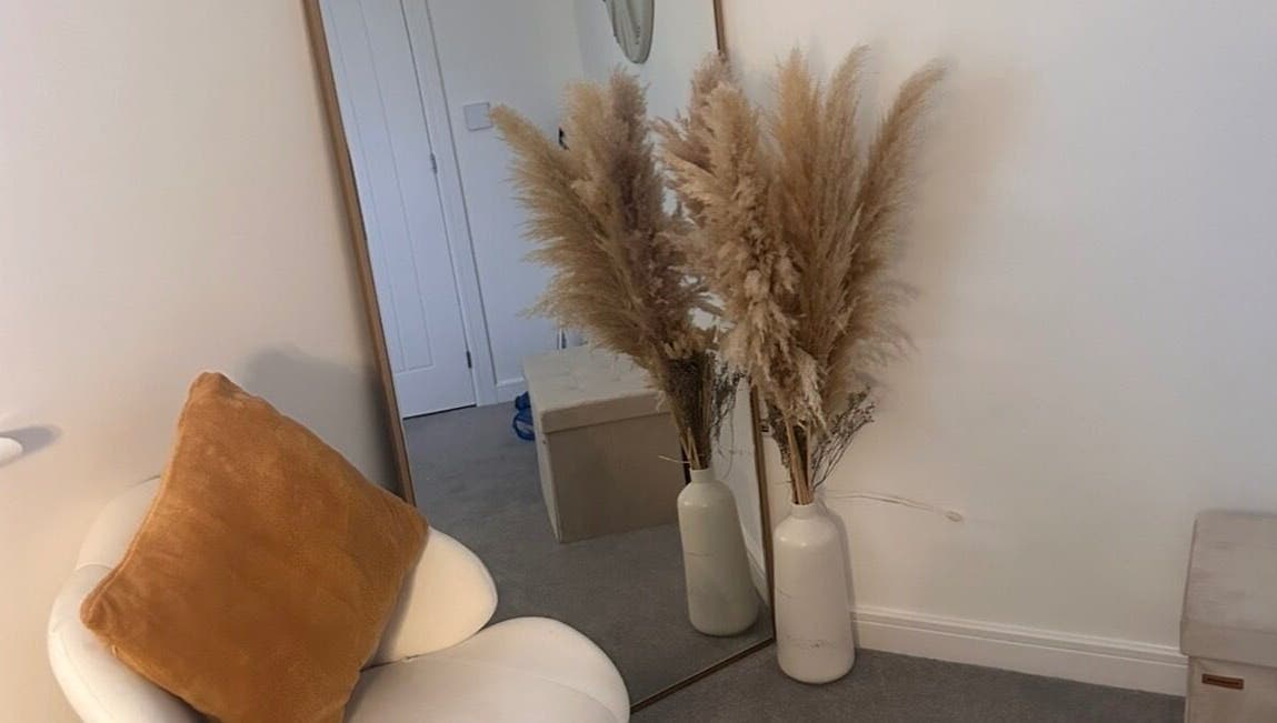 Elegant decor at Caimem Hair, Swadlincote, England, GB featuring a chair, mirror, and pampas grass in vases.